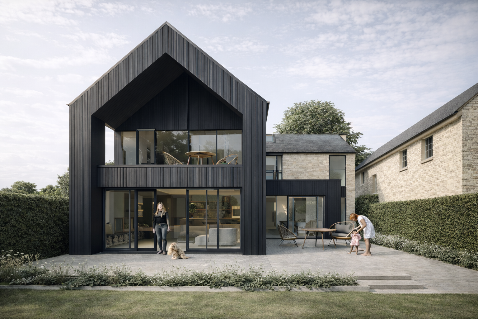 Modern two-story house with black exterior and large glass windows, outdoor patio with women and children, people sitting and playing outside, garden with hedge fencing.
