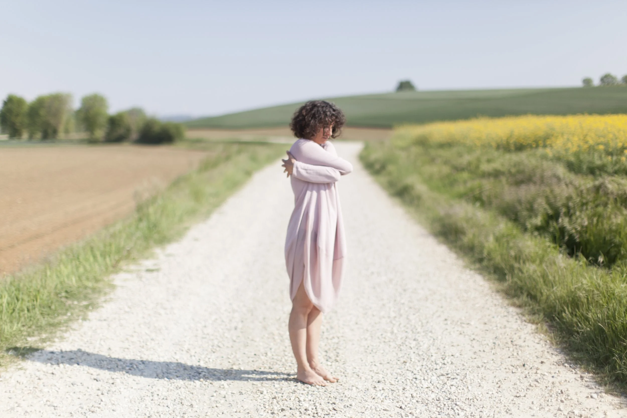 Donna sul terreno in natura che si stringe in un abbraccio