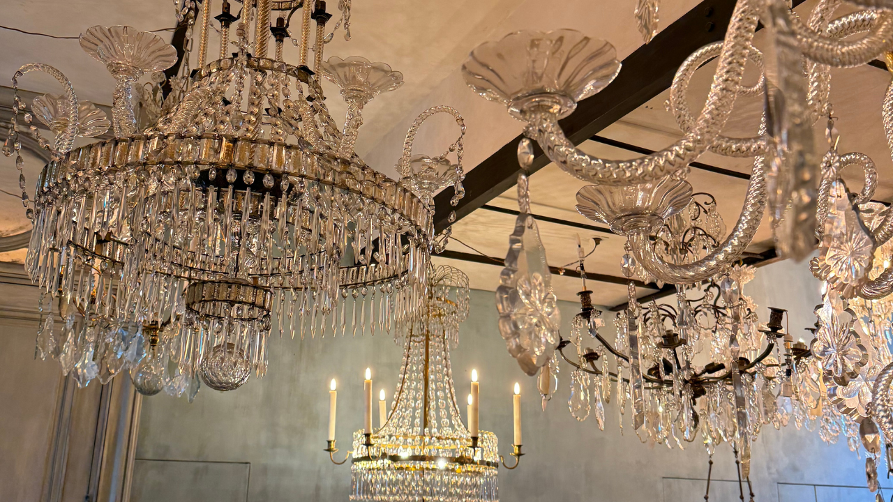 Plusieurs lustres en cristal suspendus au plafond dans une salle élégante.