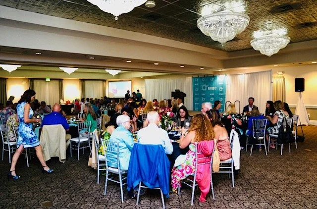 Room full of banquet tables full of people at an MWC fundraising event
