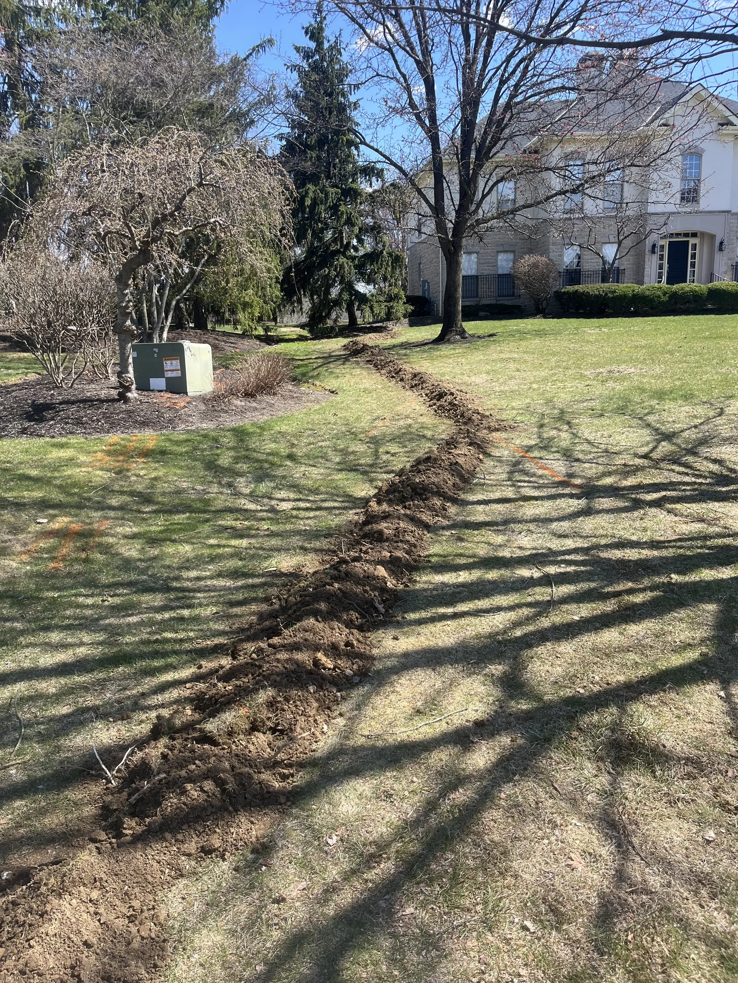 Completed yard drain installation by RonJon Plumbing in Worthington, Ohio, showing clean backfill and restored yard after drain line replacement.