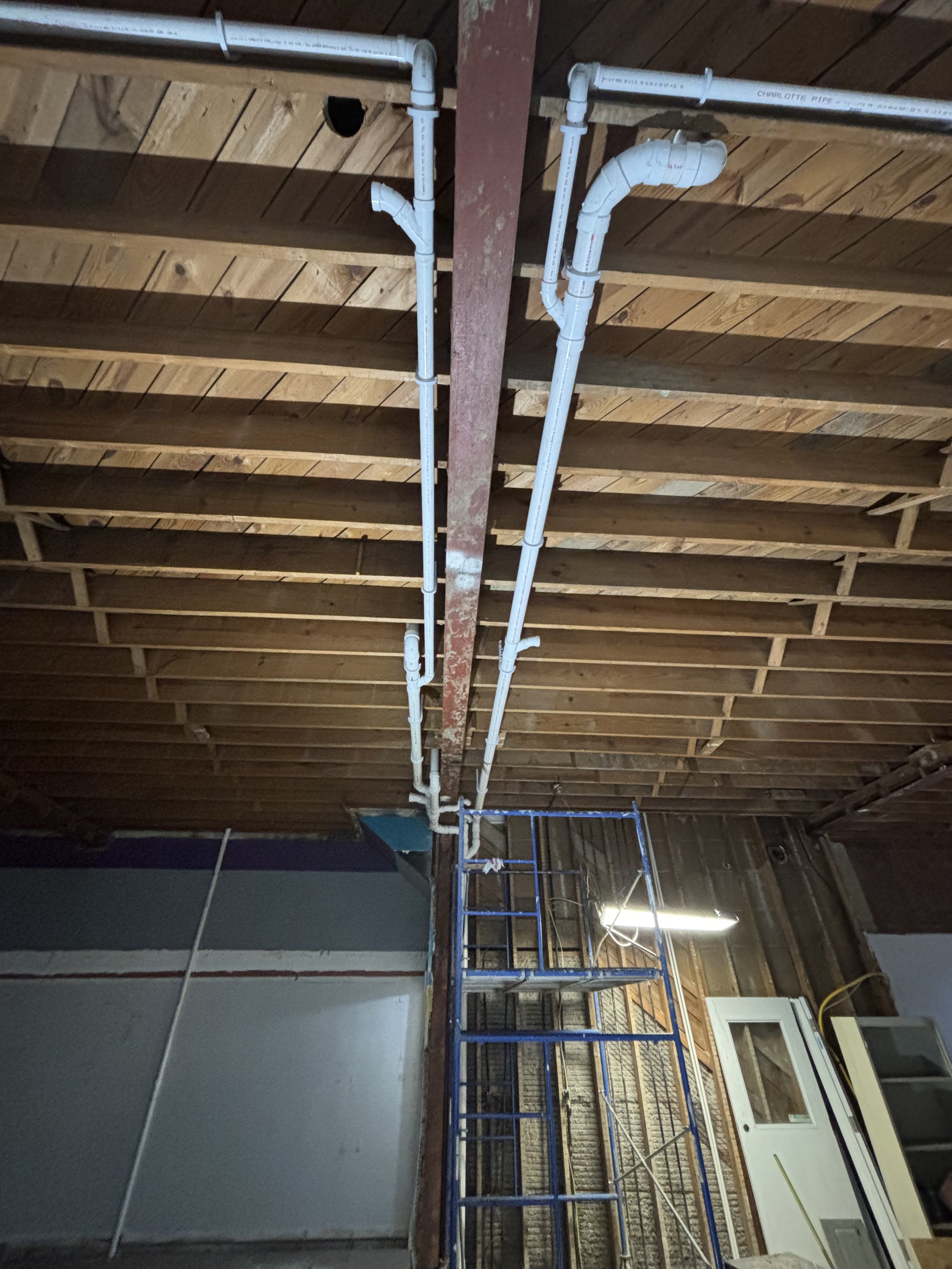 Commercial bathroom rough-in plumbing by RonJon Plumbing in Dublin, Ohio, featuring vertical drain stack and horizontal branch lines servicing three future bathrooms.