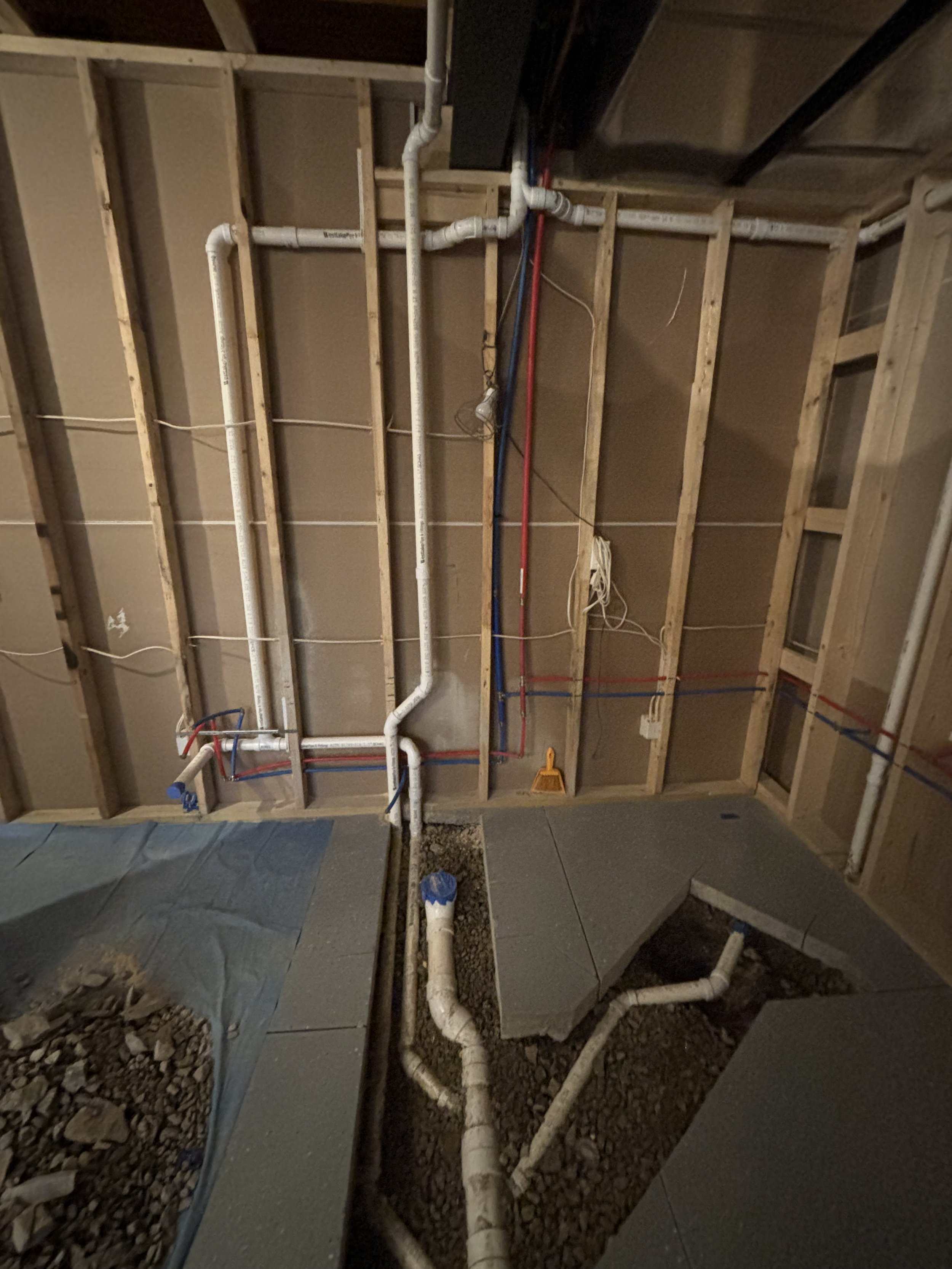 Underground plumbing rough-in for new basement bathroom showing new water lines, drain pipes, and concrete trench work by RonJon Plumbing in Centerburg, Ohio.