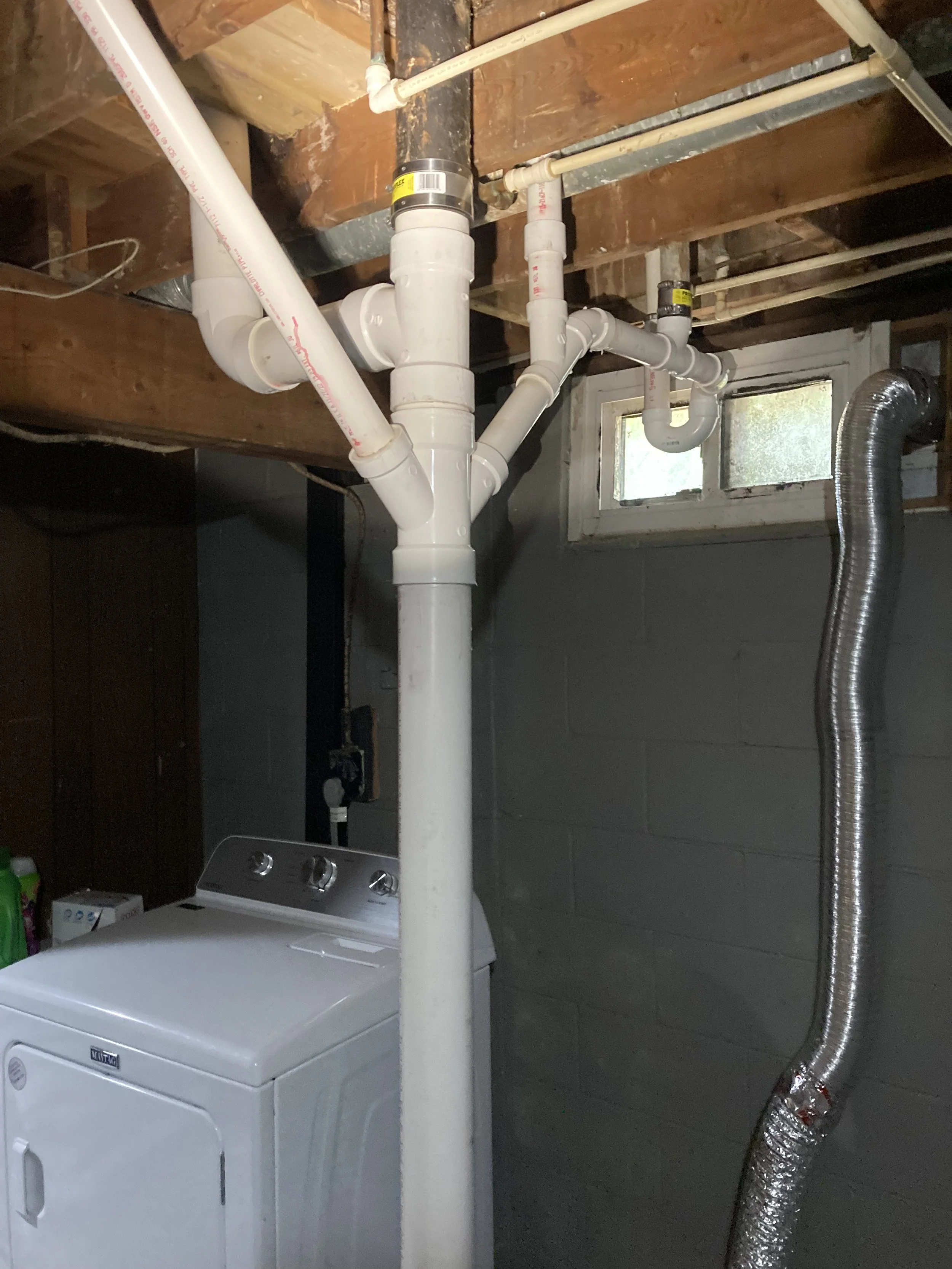 Basement stack replacement by RonJon Plumbing in Mount Vernon, Ohio, showing removal of old cast-iron piping and new PVC stack tied in with no-hub bands, picking up a toilet, tub, lavatory, and vent line.