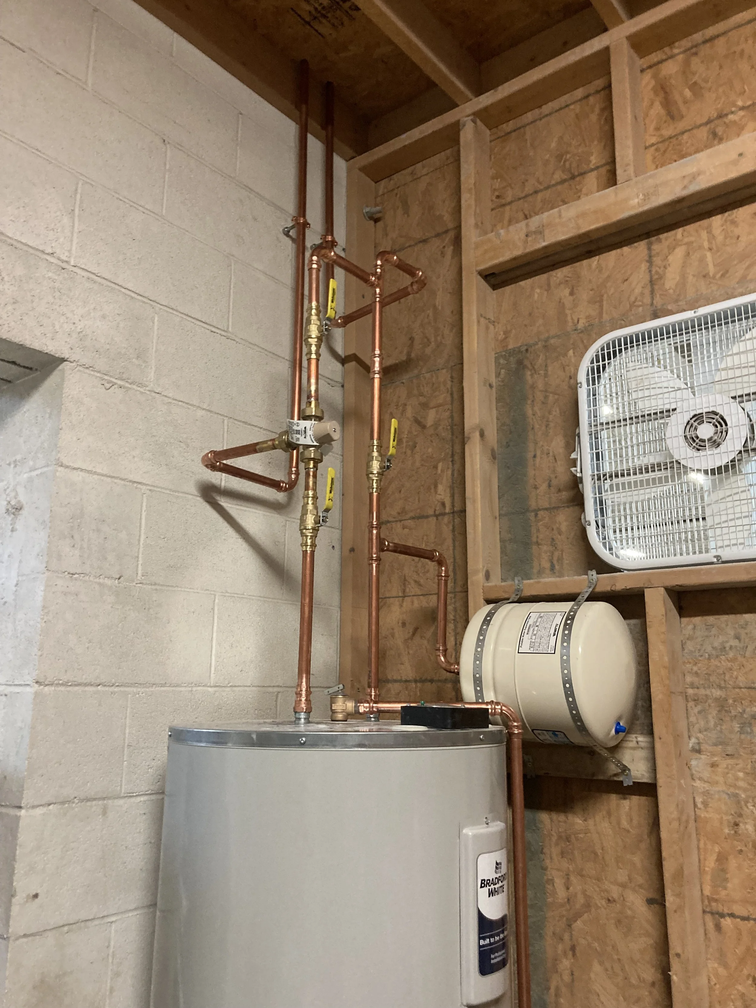 Bradford White water heater installation with expansion tank, copper lines, shutoff valves, and thermostatic mixing valve by RonJon Plumbing in Centerburg, Ohio.