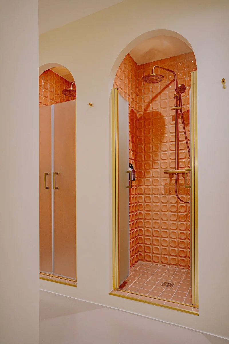 Douches séparées avec murs en carrelage orange dans un espace de salle de bain moderne.