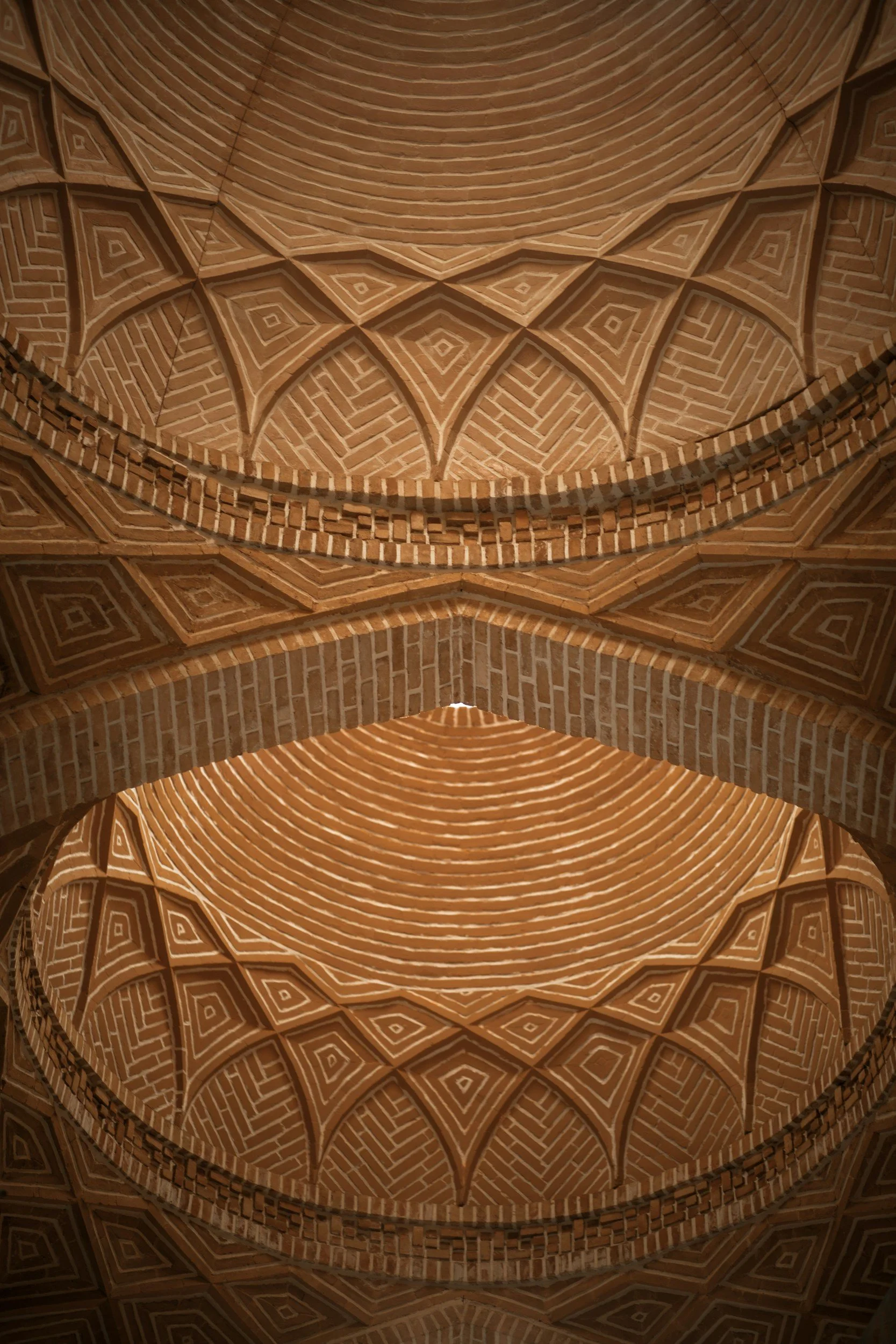 Intricate brick ceiling with geometric patterns and arches.
