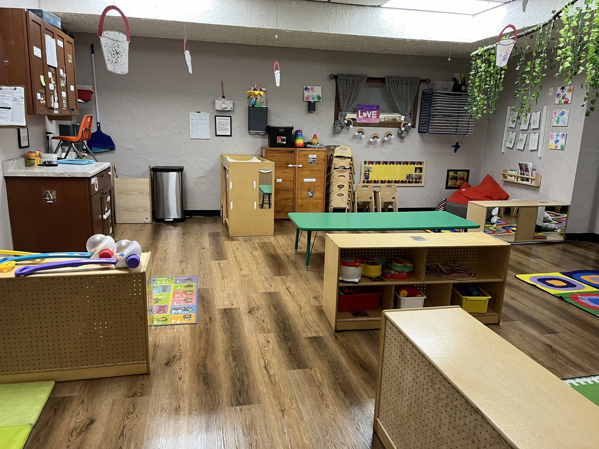 A colorful preschool or daycare classroom with various toys, furniture, and decorations.