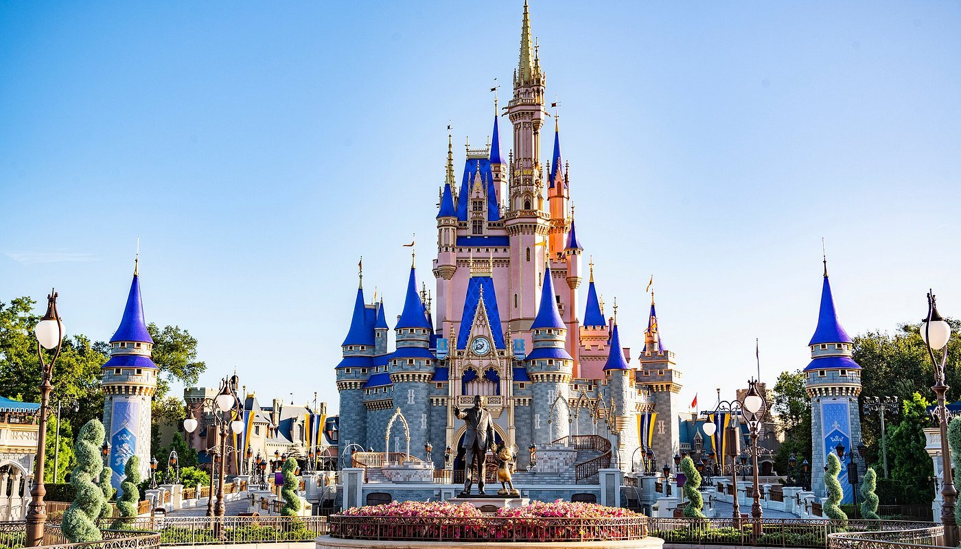 Cinderella Castle at Disney World with blue and gold spires against a clear blue sky.