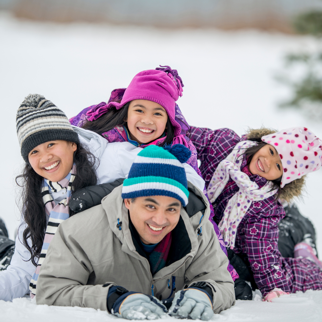 Family laying together in the snow