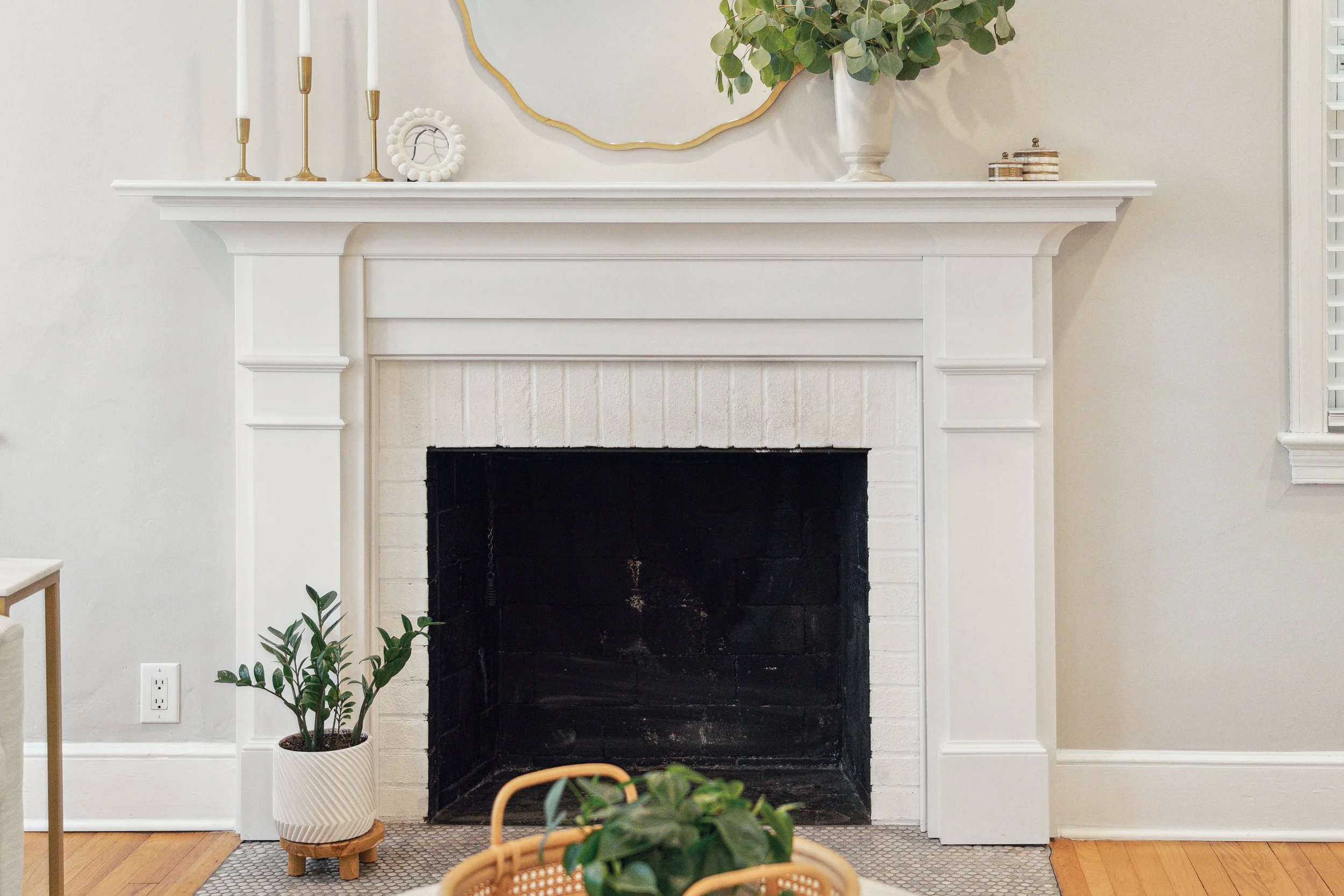 Beautiful white fireplace in a Charleston home, styled with thoughtful decor and a warm, inviting atmosphere.