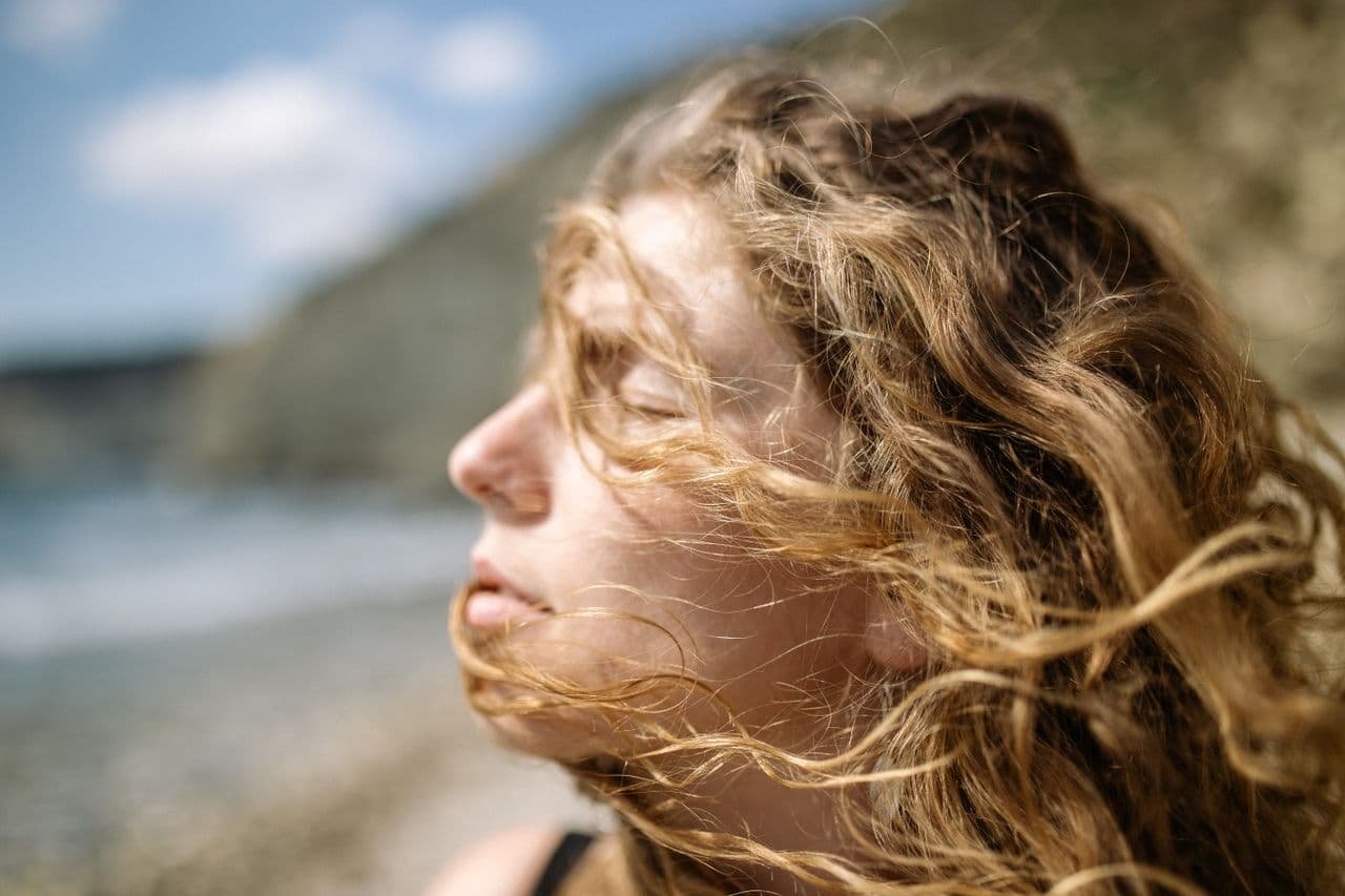 close-up-of-woman-enjoying-summer-breeze-at-sea