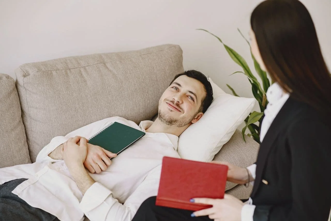 heerful-man-talking-with-therapist-and-lying-on-sofa