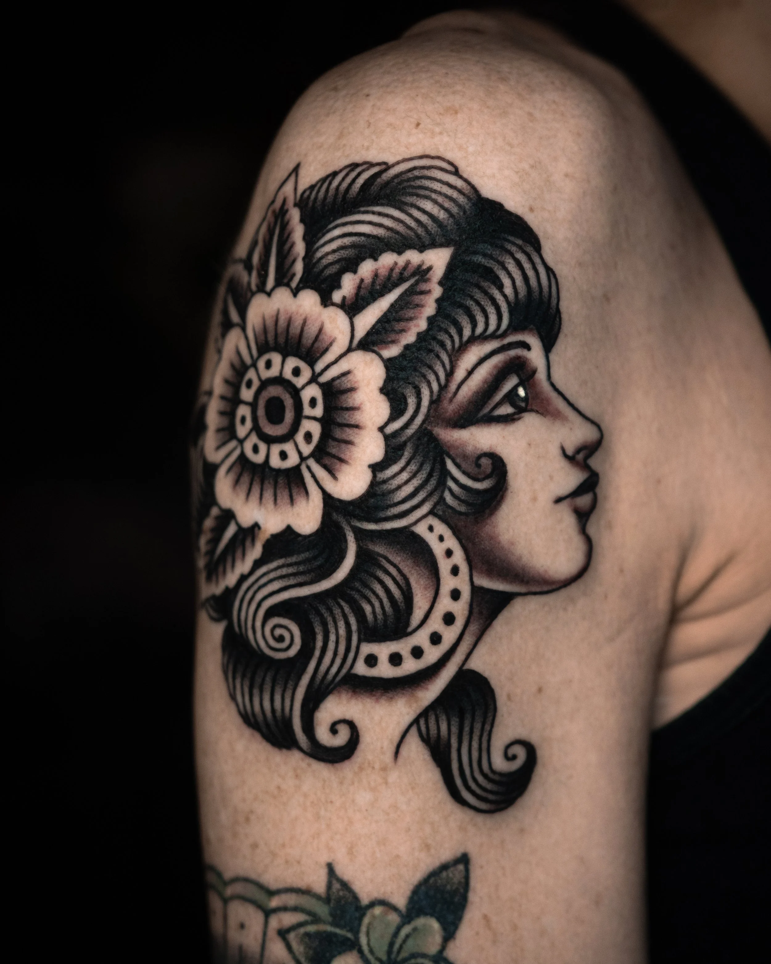 Tattoo of a woman's profile with floral and ornamental details on shoulder. Done at San Luis Tattoo Company by Danny Derrick in San Luis Obispo, CA SLO.