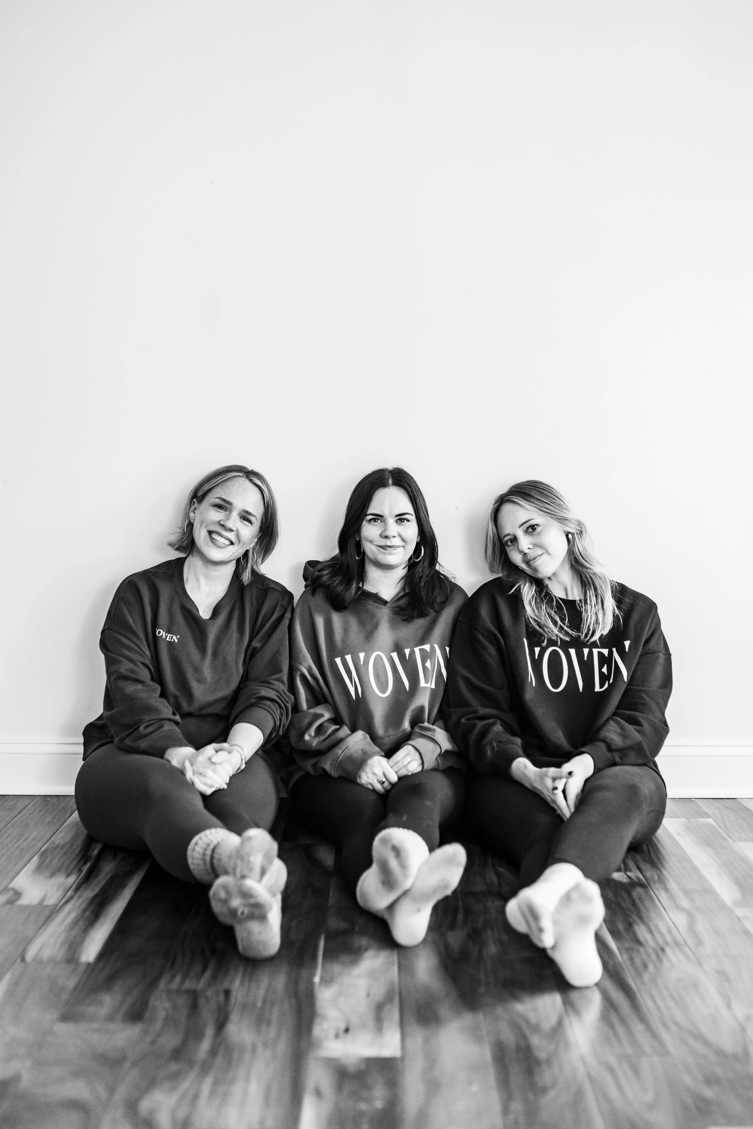 Black and White photo of three women sitting on the ground