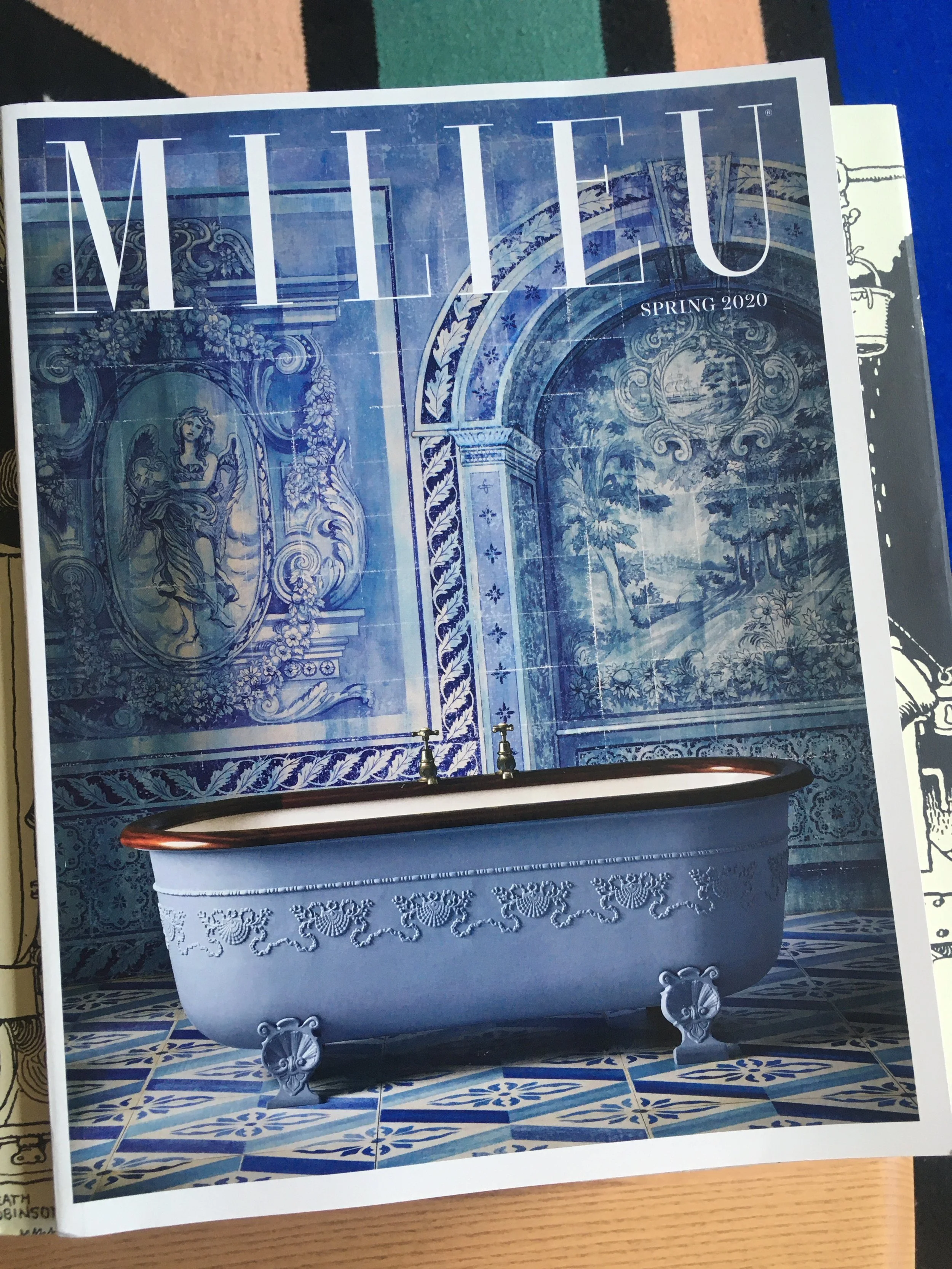 Magazine cover titled 'MILLEU' with a blue and white bathroom scene featuring a clawfoot bathtub and intricate wall and floor tiles, labeled 'Spring 2020'.