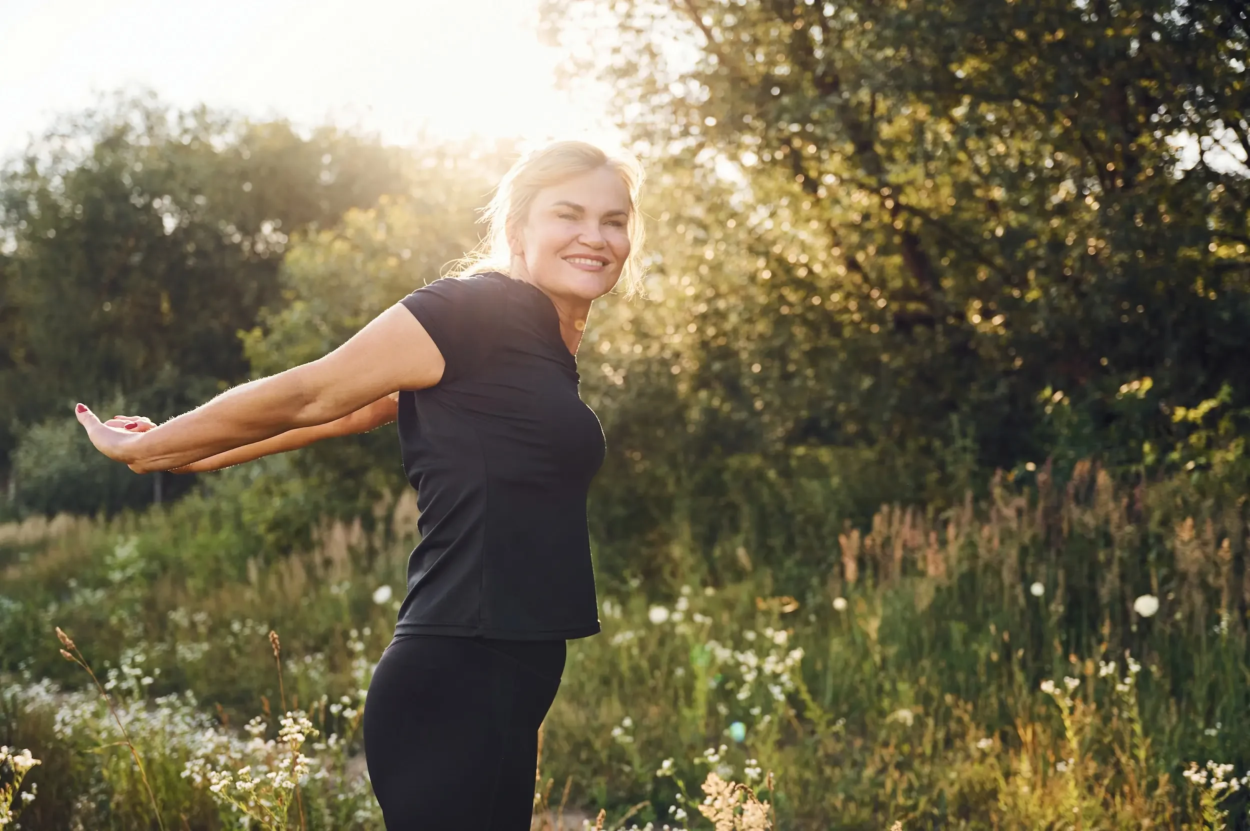 Midlife woman strength training in bright natural light, representing proactive prevention and muscle preservation during hormonal transition