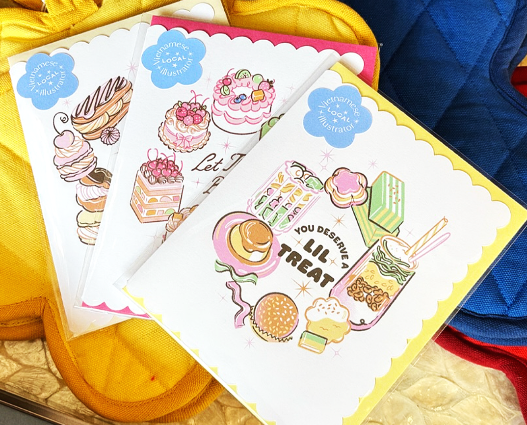 Colorful illustrated coloring sheets of desserts and sweets, with the phrase "You desiRe a lil treat" on one sheet, placed on top of backpacks in yellow, blue, and red.