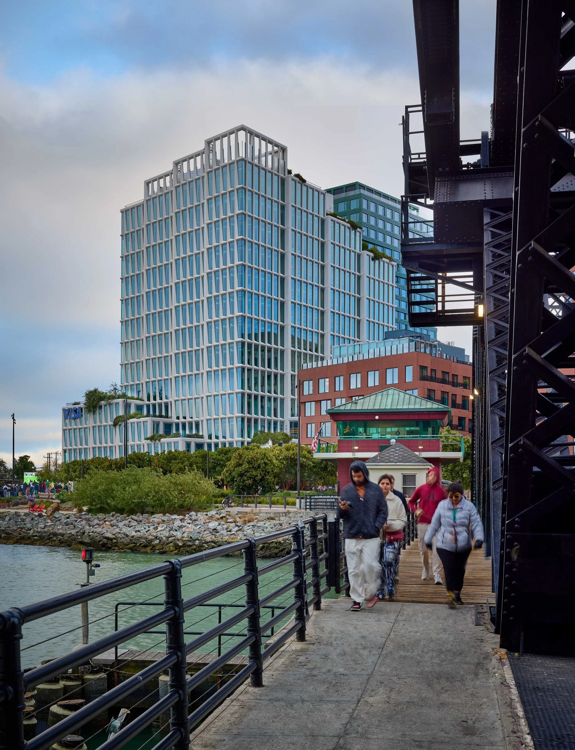 Mission Rock Block G viewed from the waterfront promenade, with stepped terraces and landscaped rooftops.