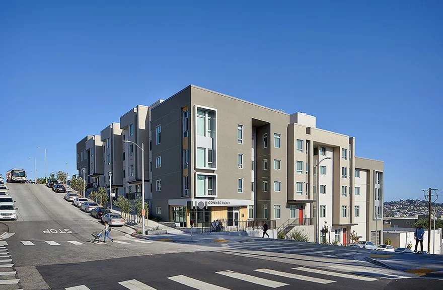 1101 Connecticut affordable housing viewed from a steep San Francisco intersection under a clear blue sky.