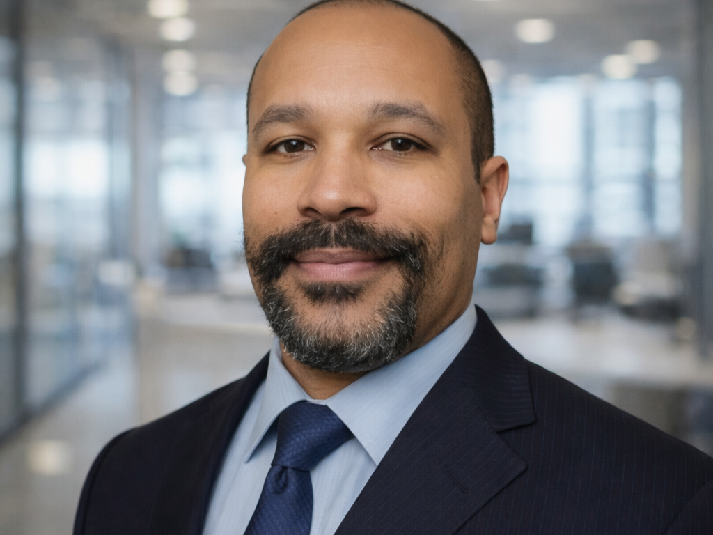 Black and white portrait of a man in a suit and tie with a unique beard.