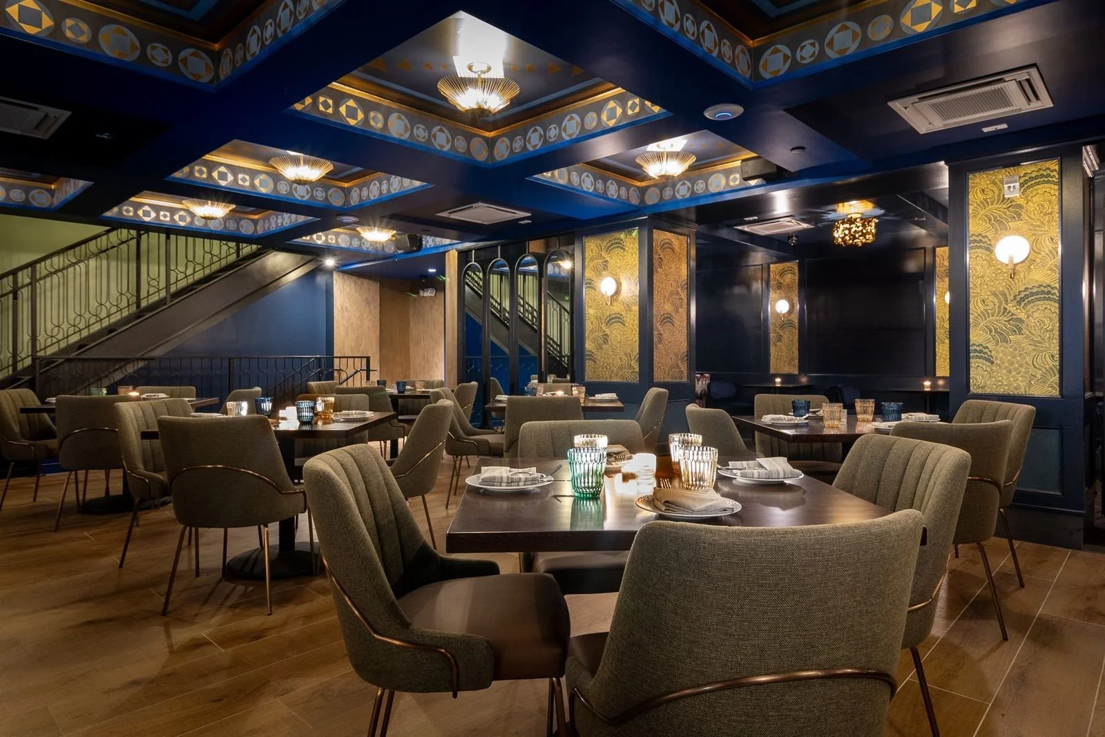 Tables for groups under a coffered ceiling with gold panels