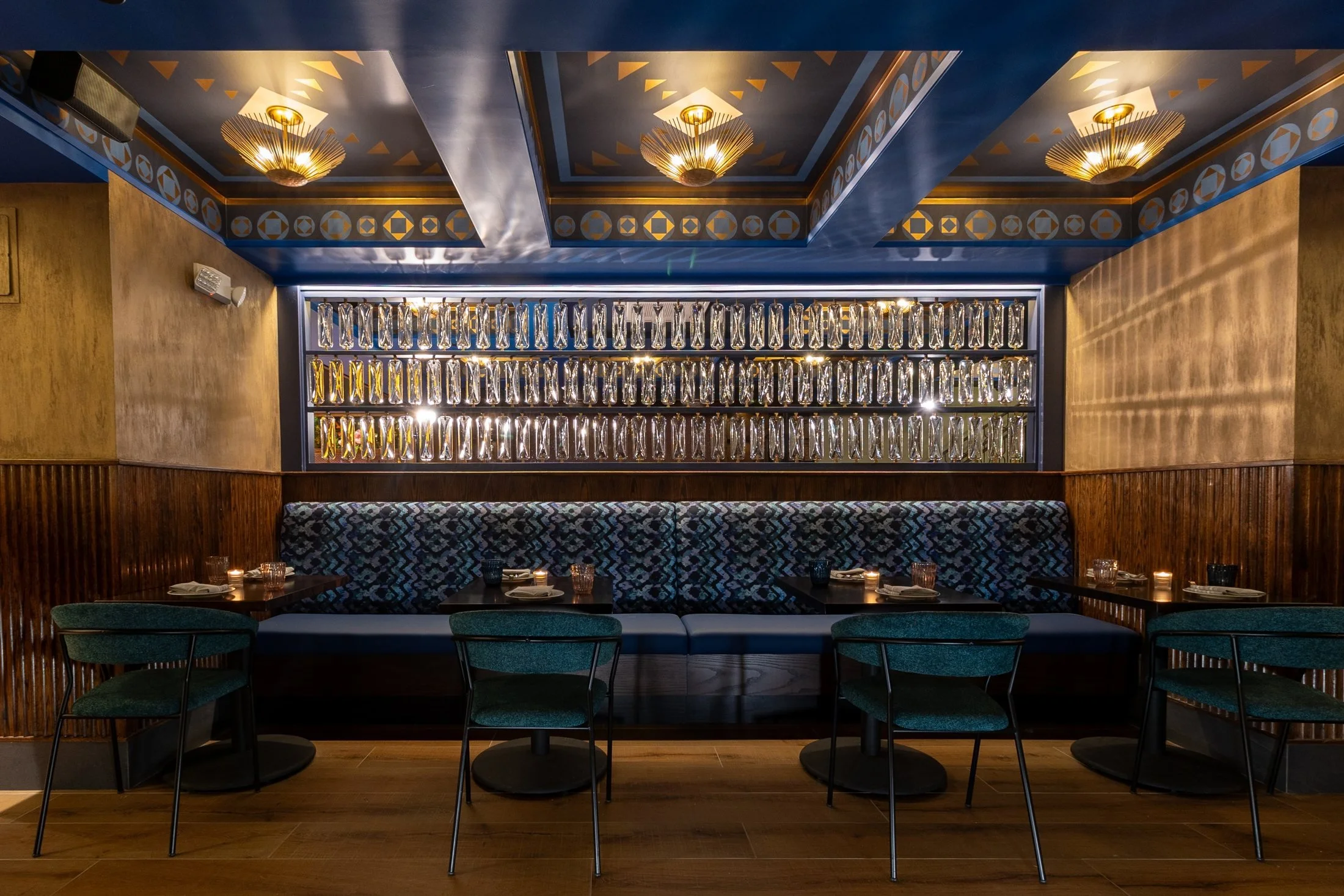 Teal banquette seating and gold panels in the former Alessa lounge