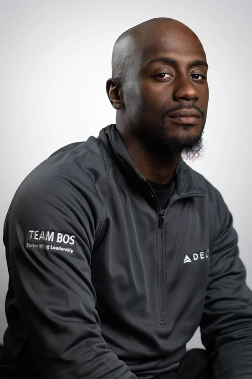 Professional portrait of a man in a dark jacket against a light gray backdrop