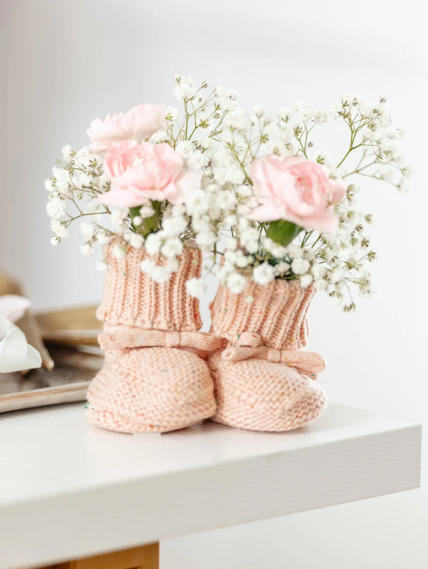Pink baby booties filled with delicate flowers