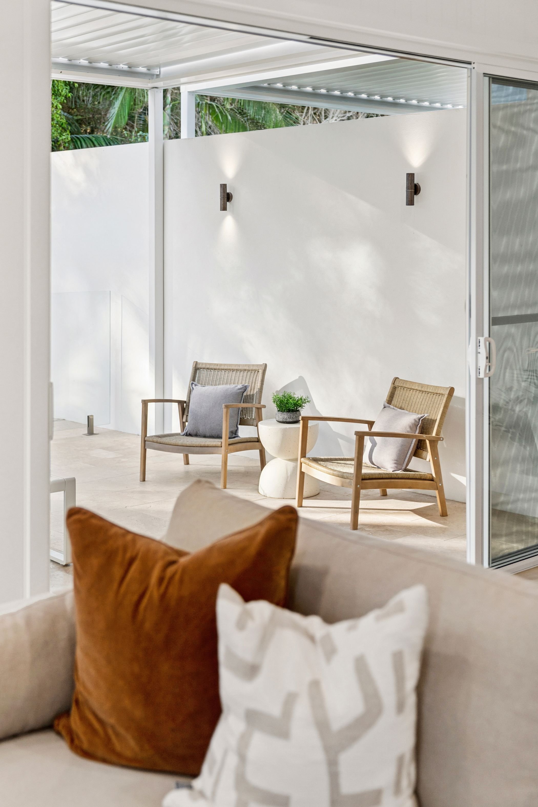 Custom built duplex project in Port Macquarie features large windows and glass sliding doors out to alfresco area and pool.