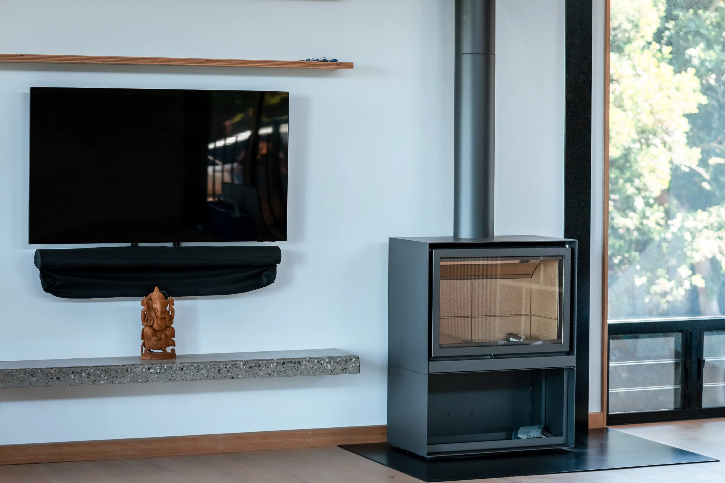Living room in luxury residential construction project in Port Macquarie, including large windows and modern wood heater.