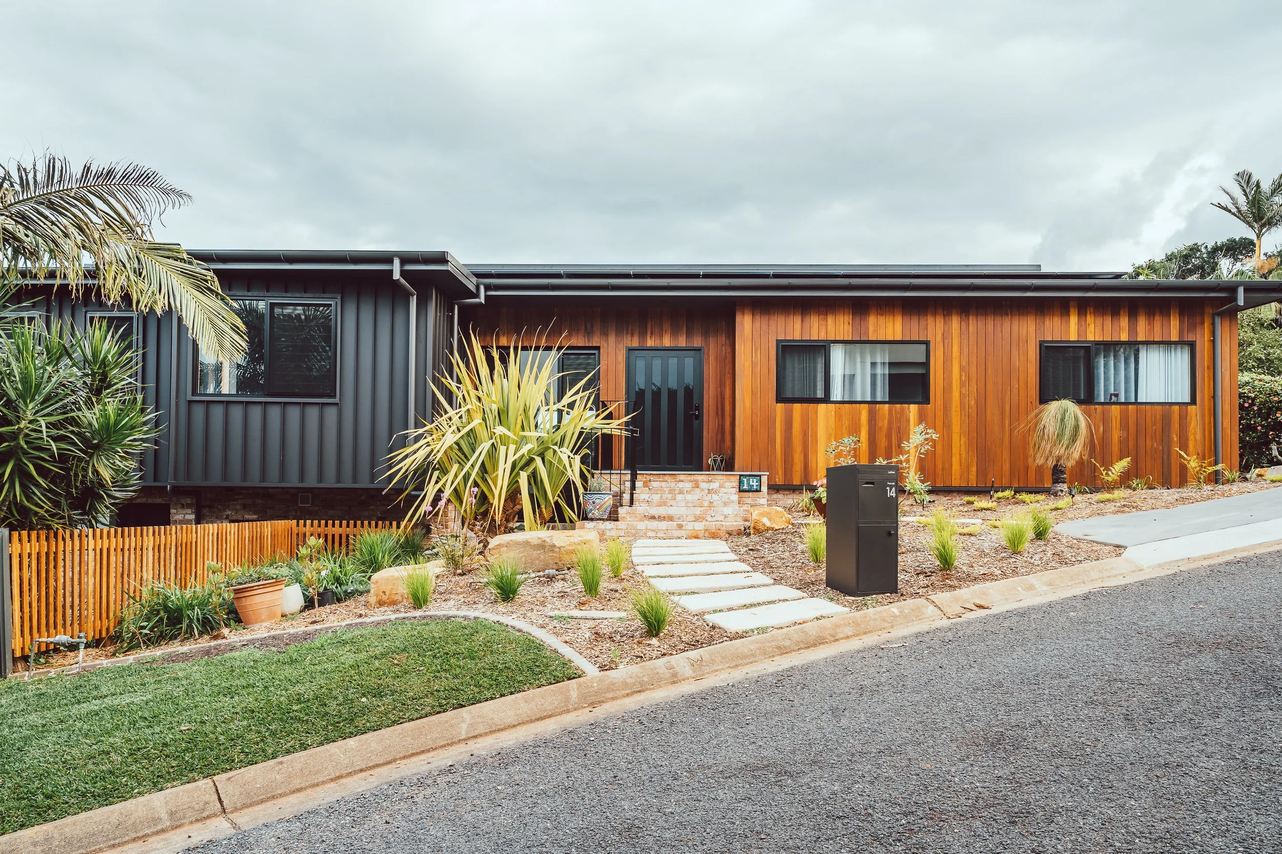 Luxury architecturally-designed residential project in Port Macquarie includes recycled brick, black metal and timber exterior surrounded by beautifully landscaped garden.