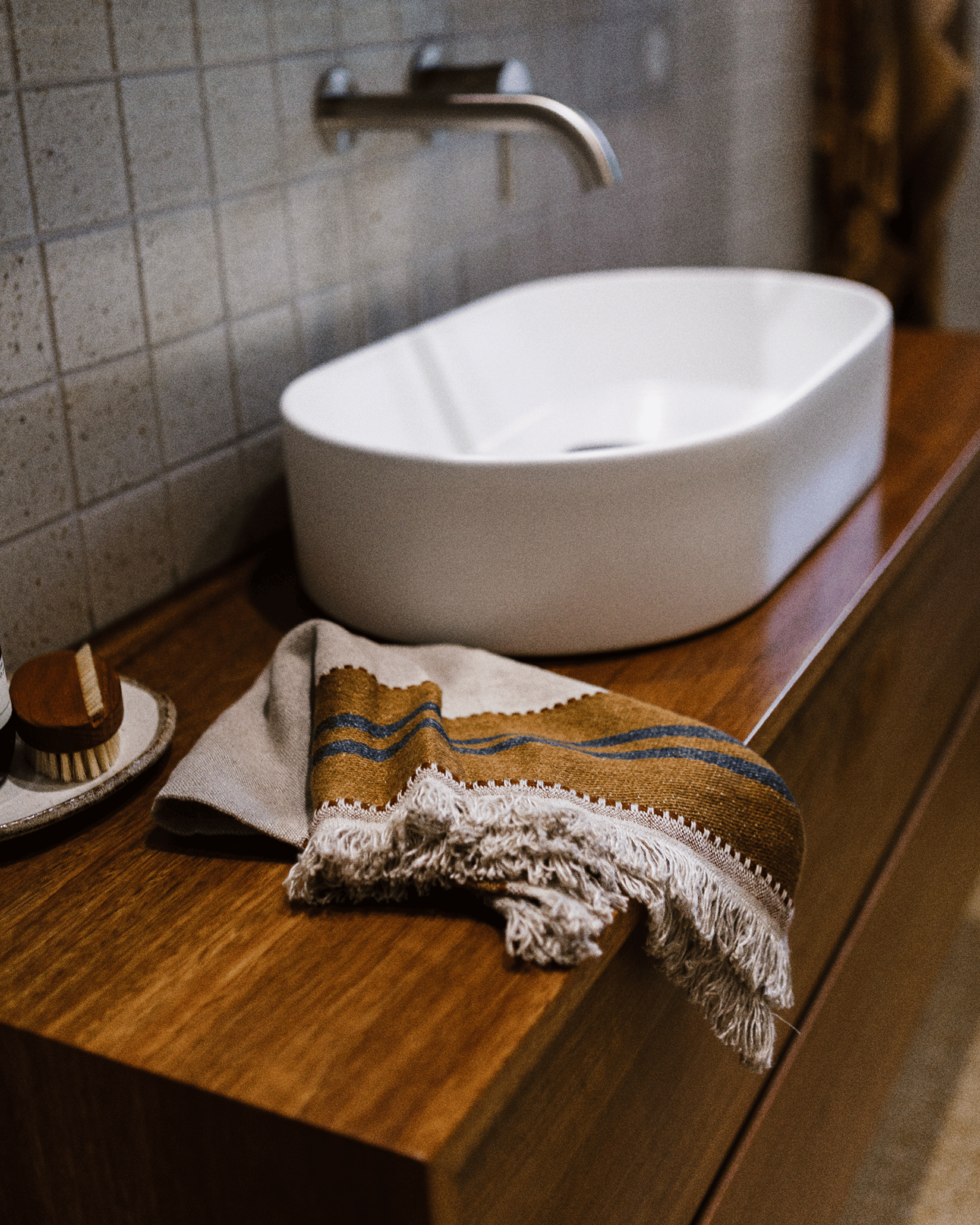 Timber vanity detail with vessel basin, brushed nickel wall spout and natural linen textiles.