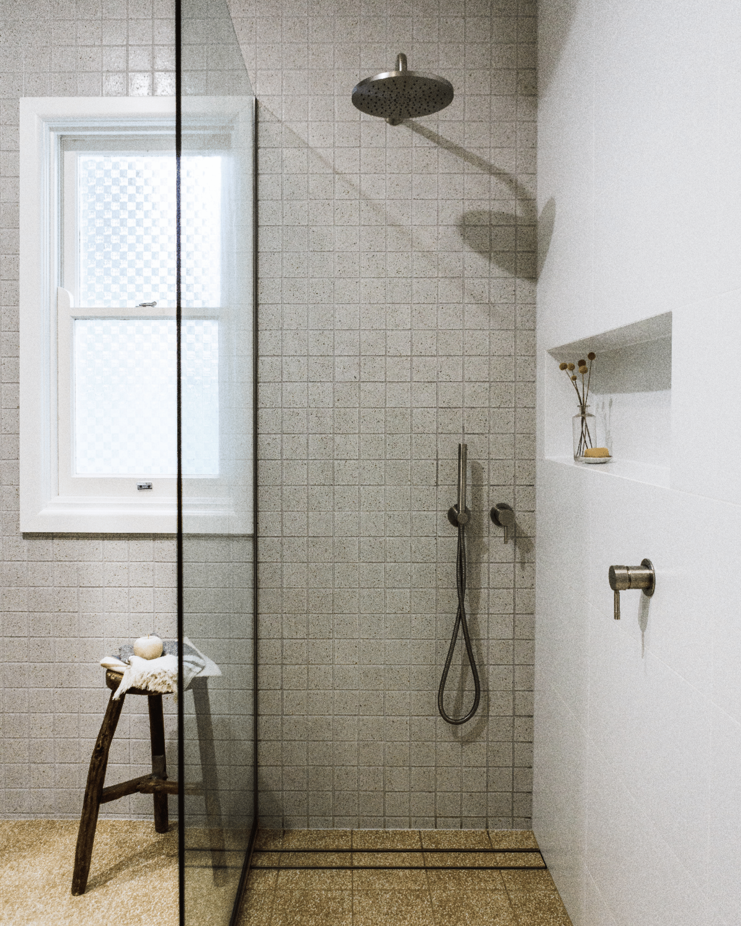 Walk-in shower with frameless glass screen, brushed nickel fittings and recessed shower niche.