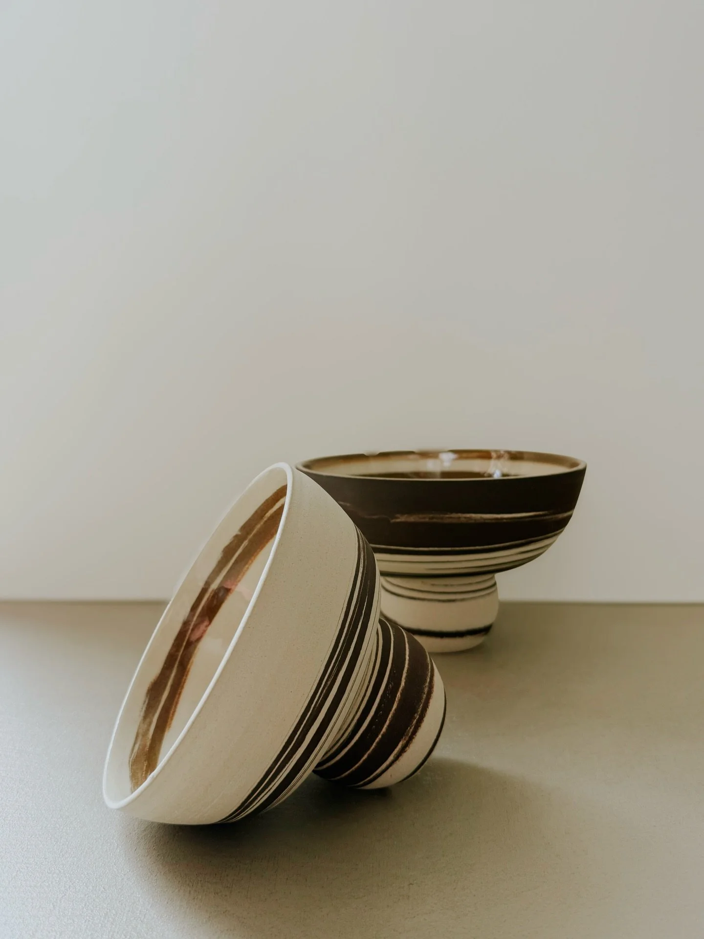 Now availabe on our shop - This large marbled bowl on foot is hand-thrown from black and neutral stoneware clay, creating a dramatic spiral unique to each piece. Its generous size makes it perfect for serving, display, or as a sculptural centerpiece.