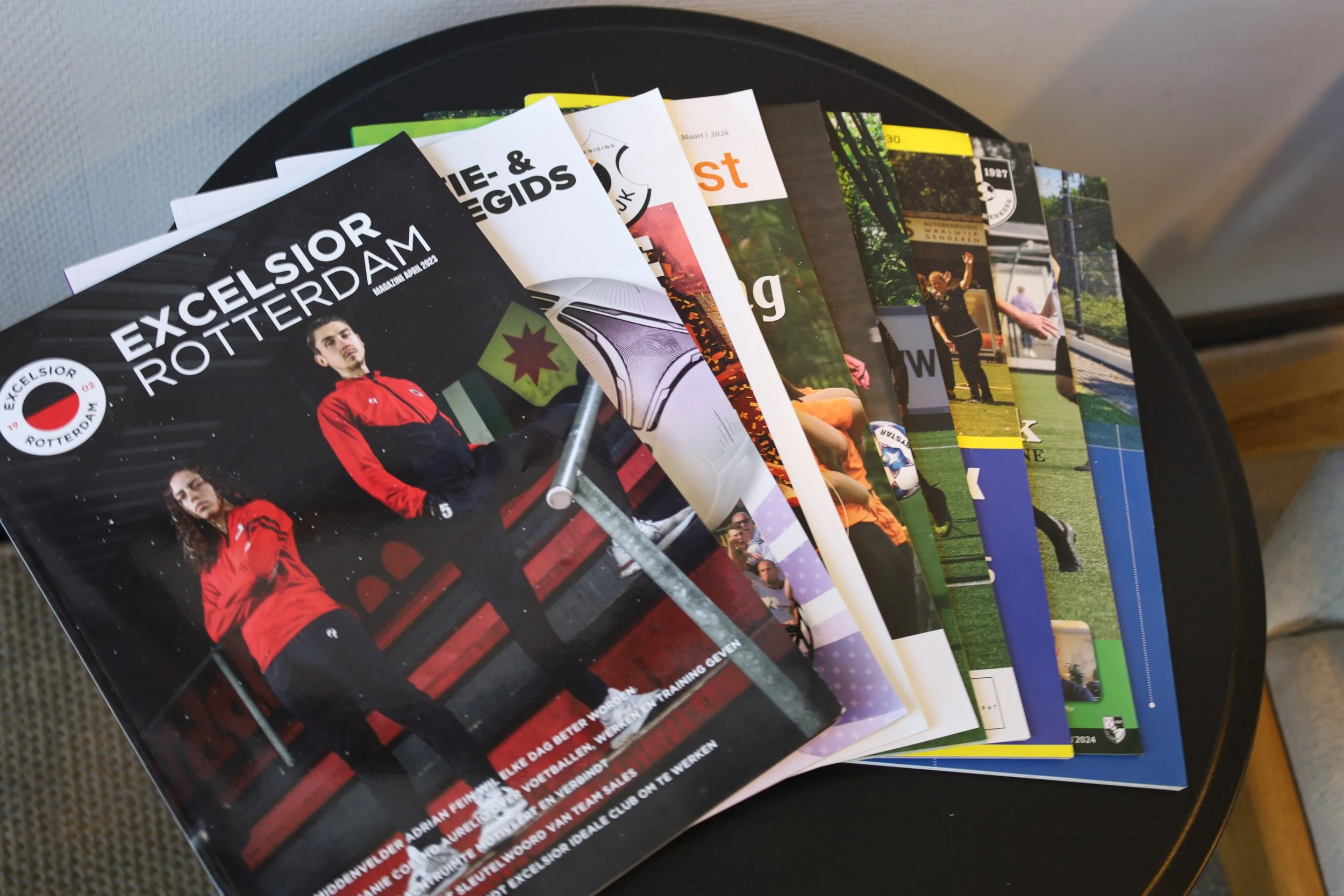 Een stapel tijdschriften, met de voorpagina van 'Excelsior Rotterdam'.