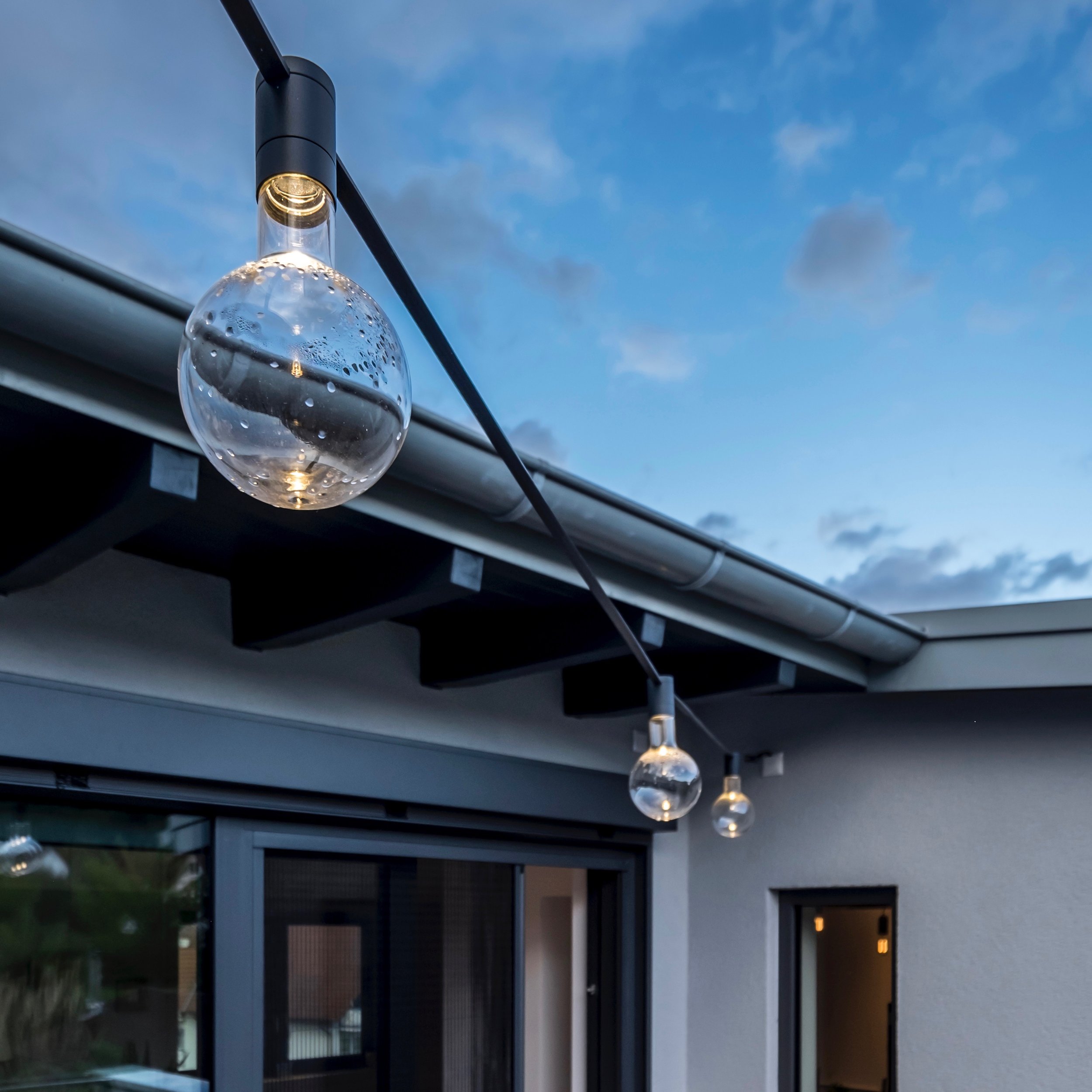 Die Terrasse wird mit wasserdichten LED-Profilen und einer dekorativen Girlande von Viabizzuno beleuchtet.