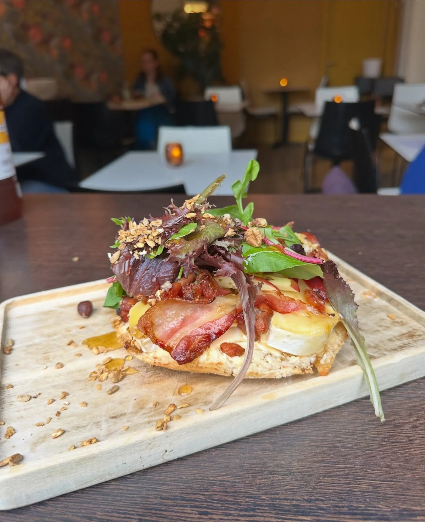 Onze heerlijke flammkuchen is de ideale lunch tijdens je shopping trip in Antwerpen. De herfst op een bordje! Geniet van de heerlijke combinatie van brie, appel, gerookt spek, granola en honing 🍯