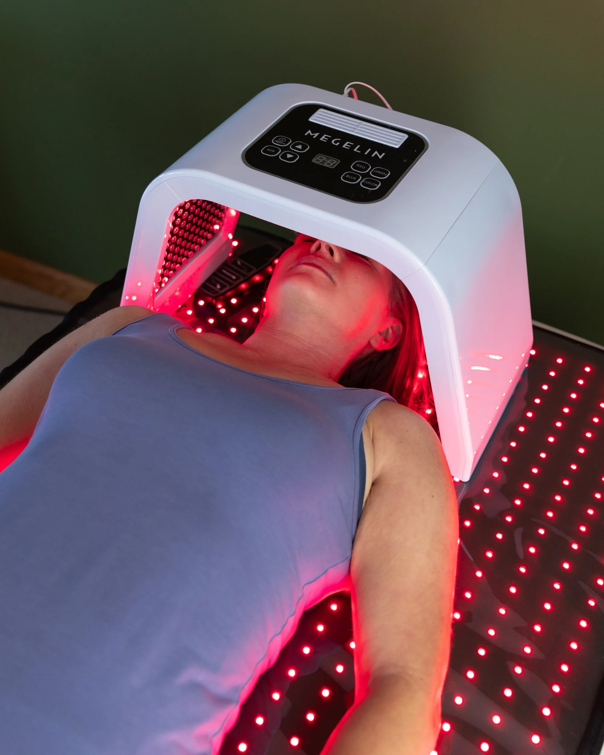 Woman receiving red light therapy treatment with a Megelin device