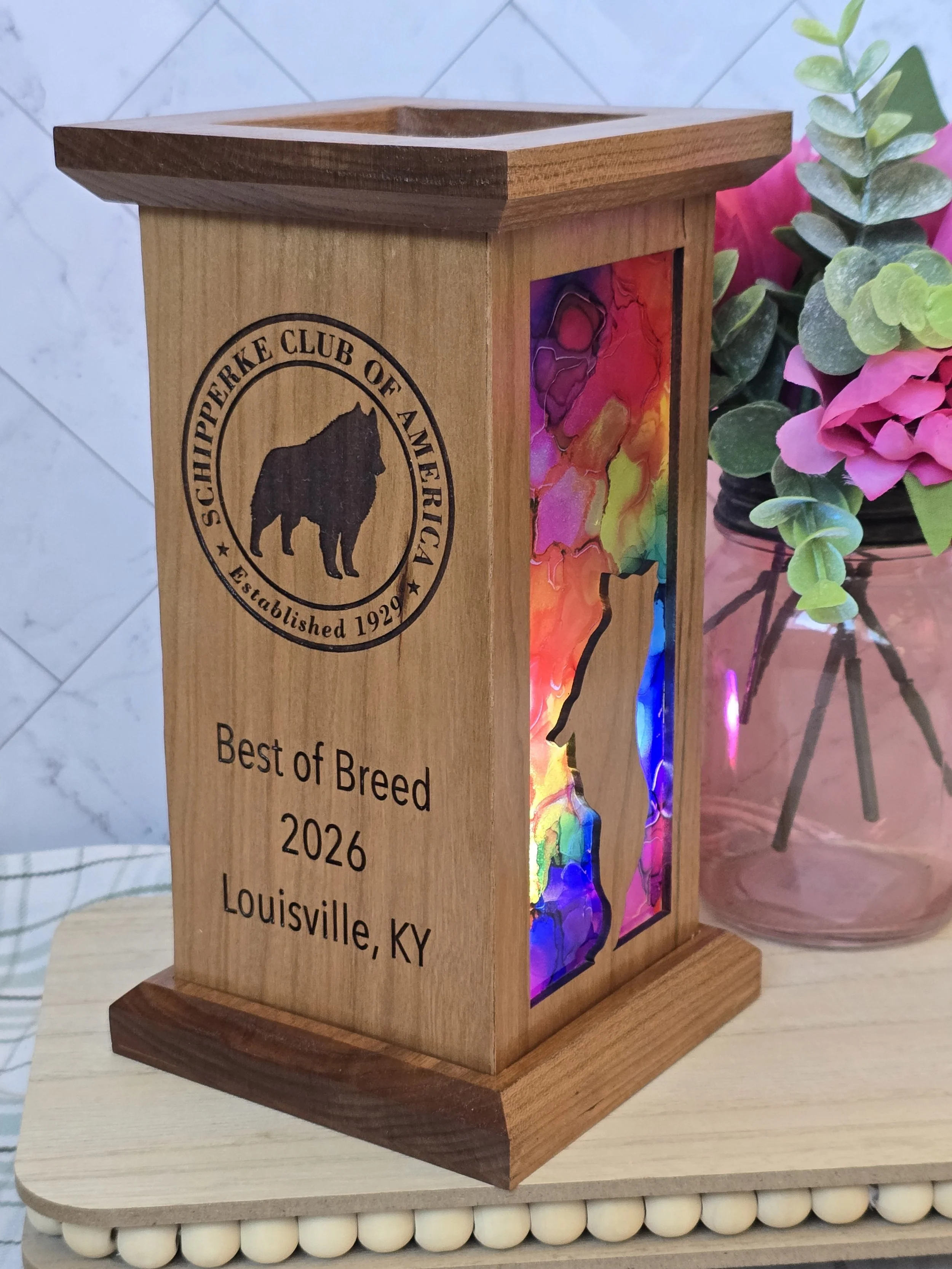 A wooden award plaque with a colorful mosaic art panel, engraved text showing it is for the Best of Breed 2026 from Louisville, KY, and a logo of the Scottish Terrier Club of America.