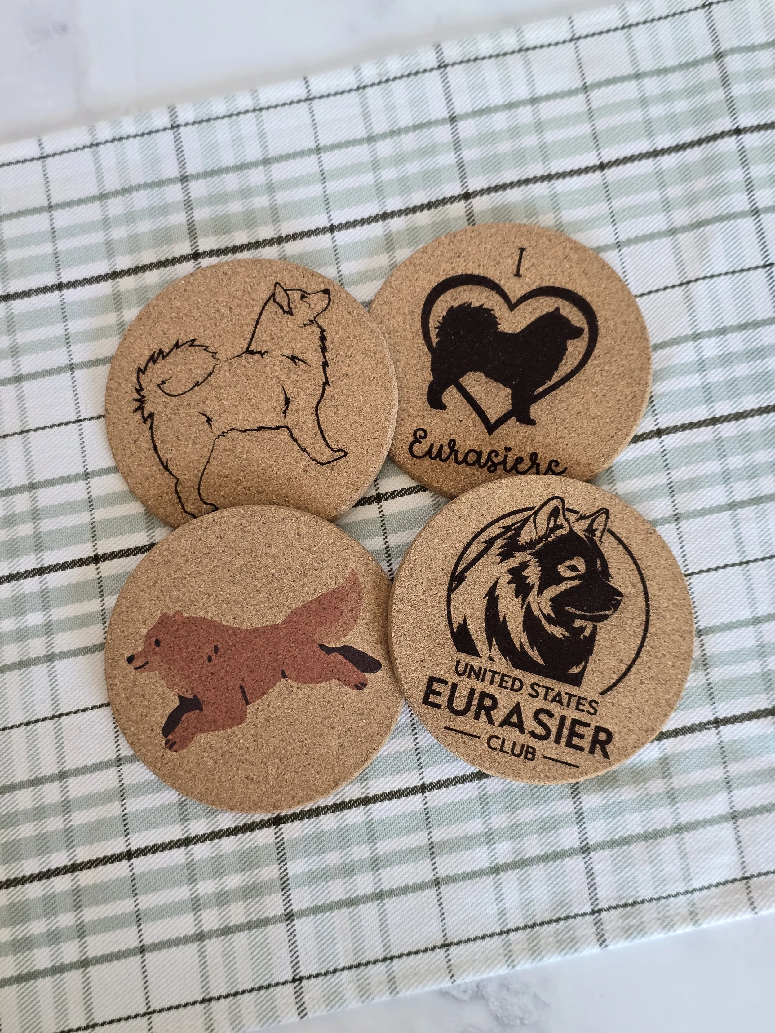 Four round cork coasters with Eurasier designs and the United States Eurasier Club logo