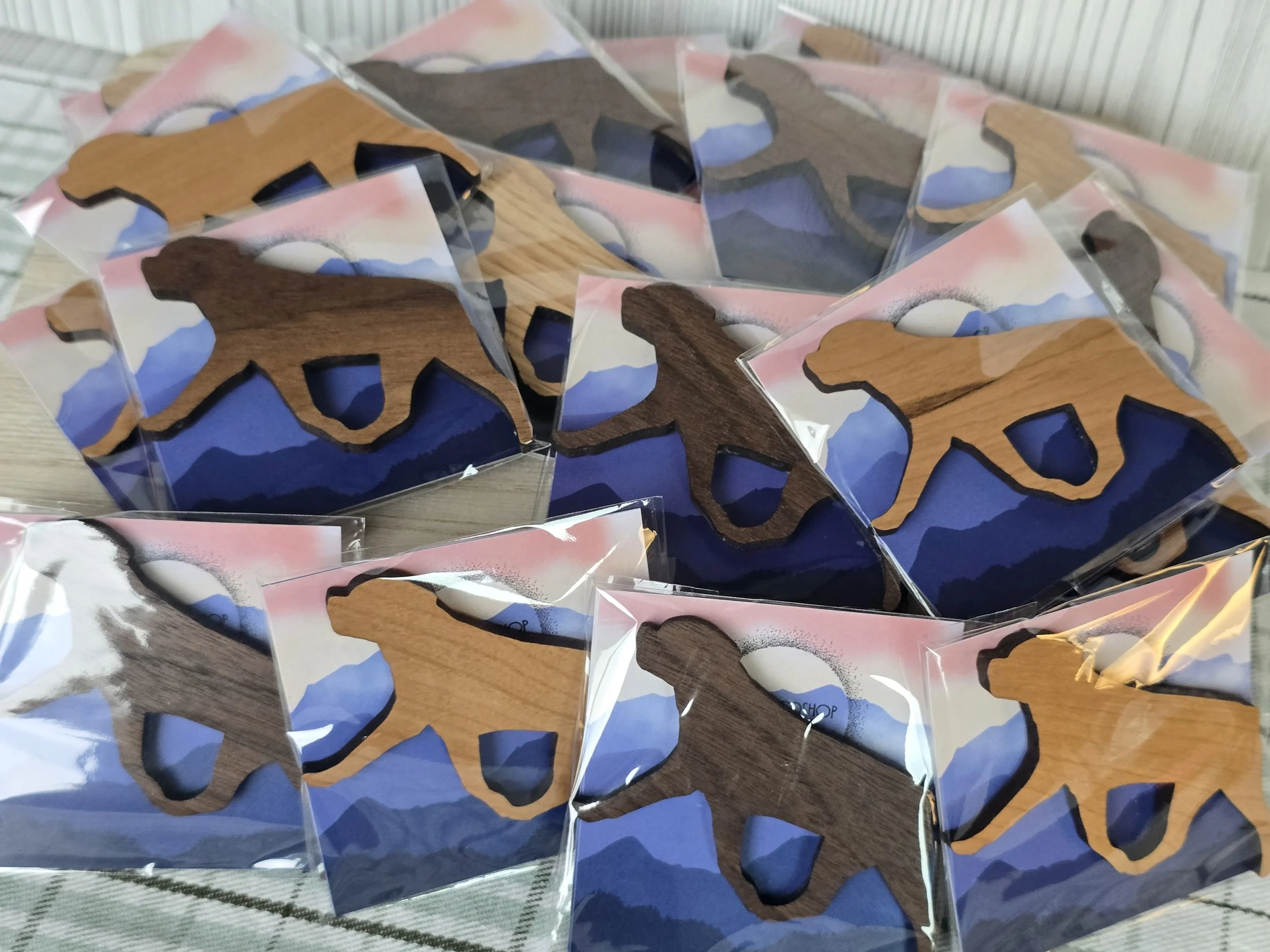 Close-up of multiple packaged wooden magnets in the shape of a Rottweiler.