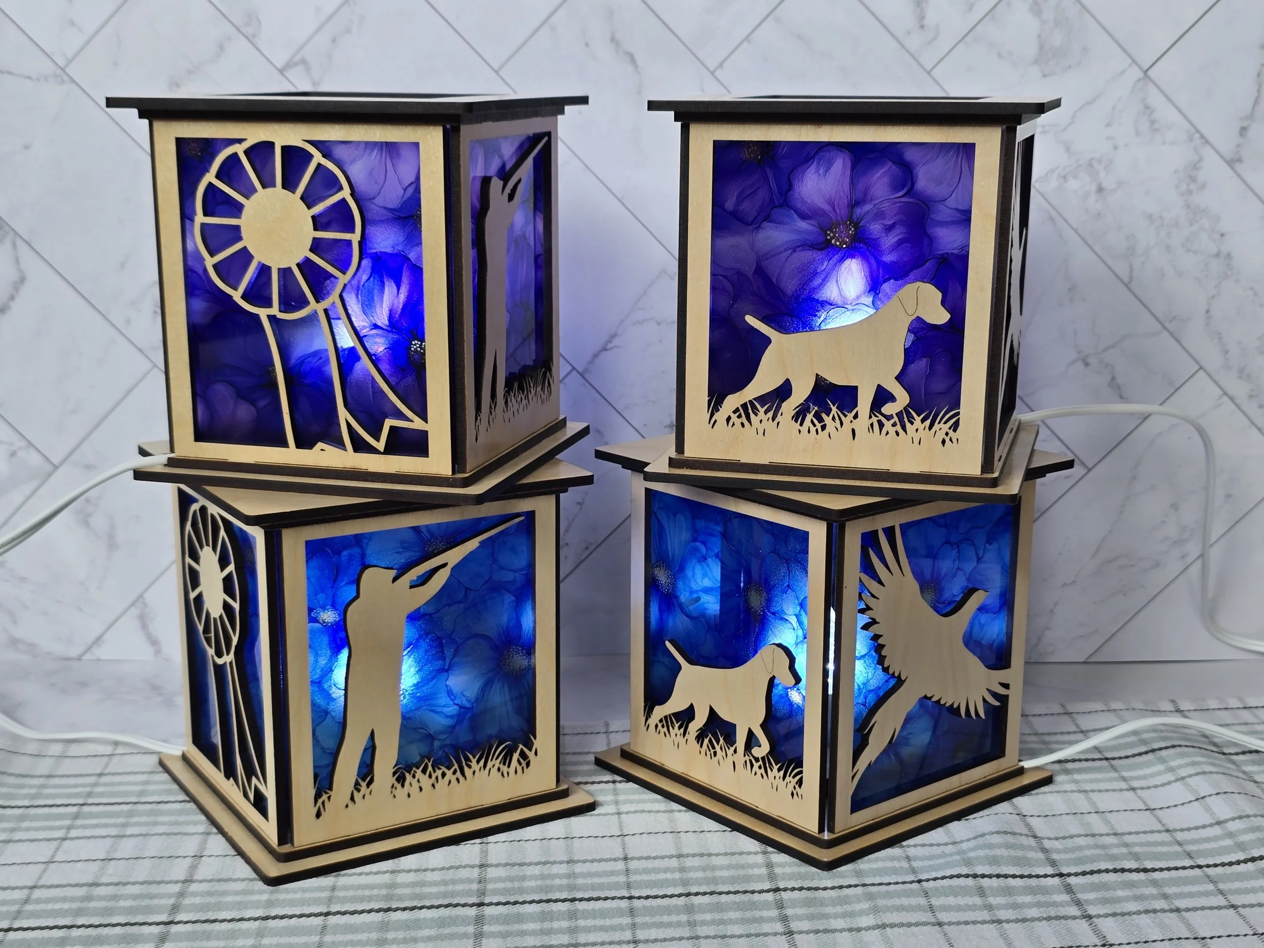 Three layered lanterns in blue acrylic with a rosette, a Vizsla, a handler and a flying pheasant