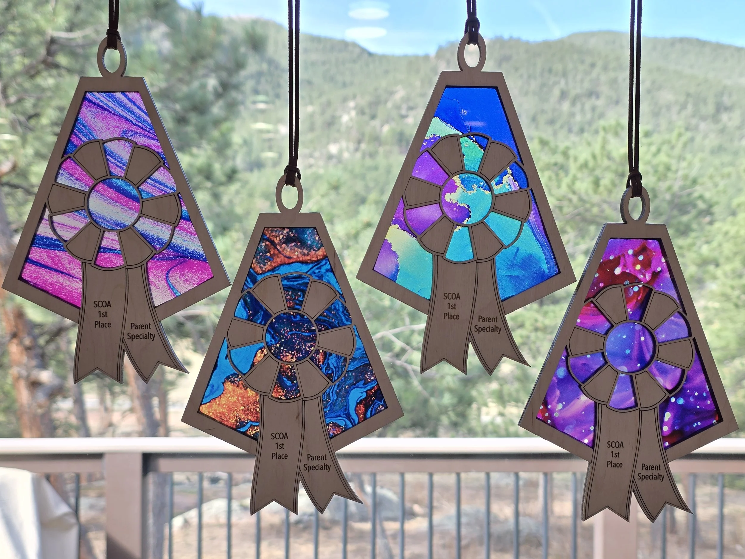 Four rosette acrylic suncatchers engraved SCDA 1st Place Parent Specialty on patterned acrylic