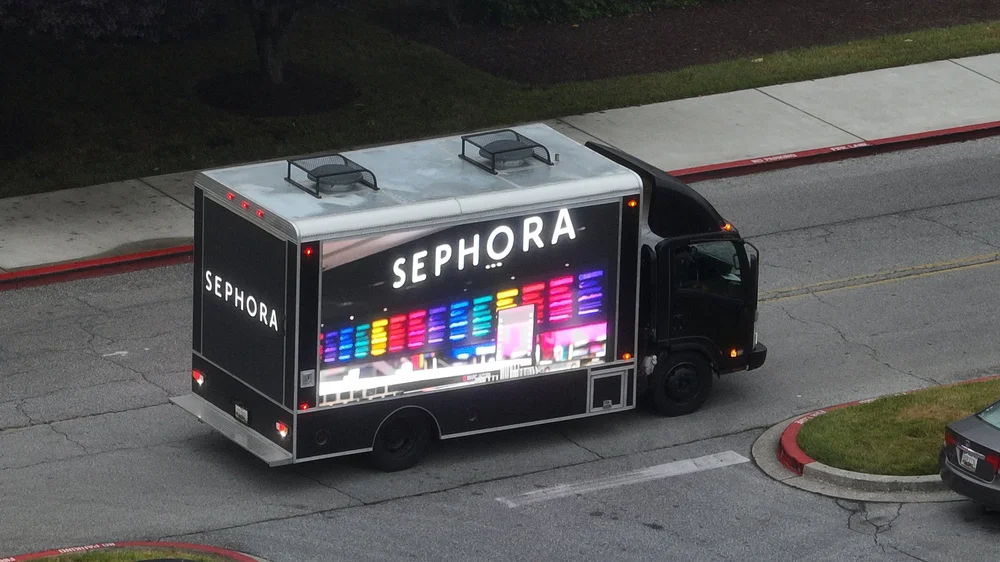 Aerial view of the LED truck driving a retail corridor with a Sephora ad