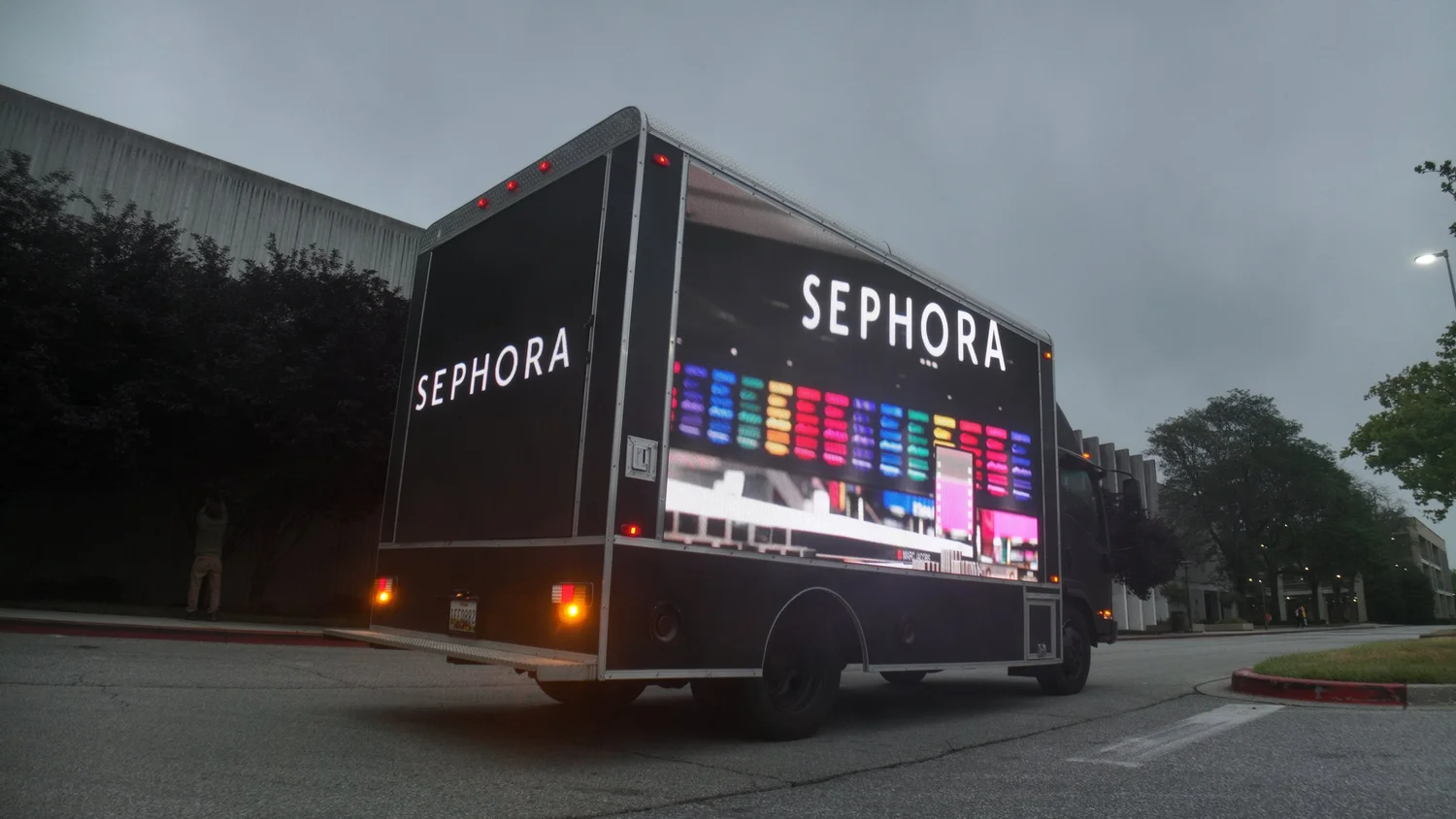 LED billboard truck at dusk with a bright Sephora ad glowing on the side panel