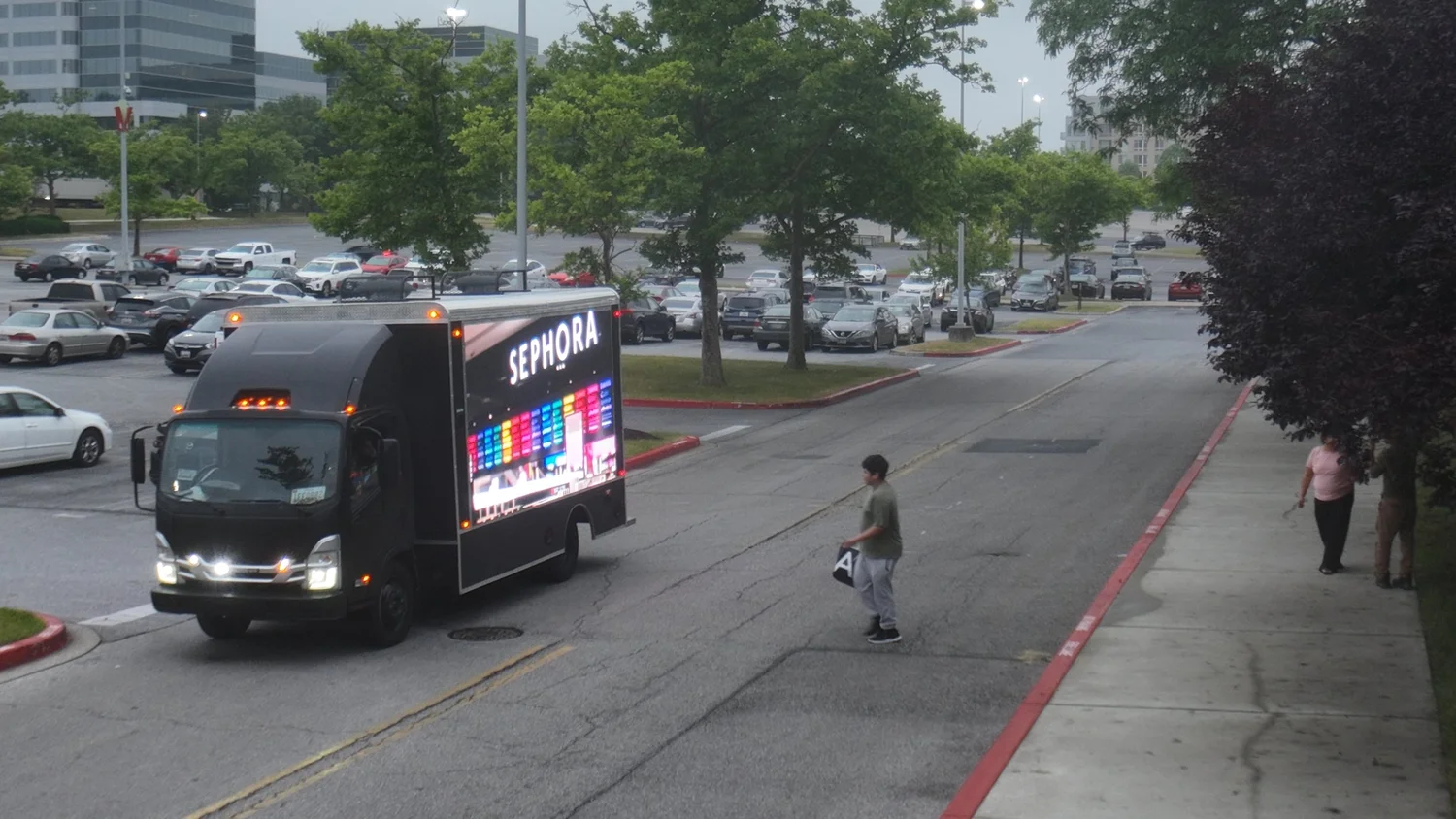 LED billboard truck driving through a parking lot with a Sephora ad