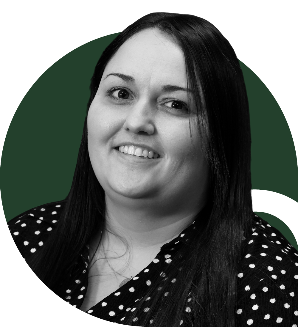 Two large wind turbines on a grassy field under a partly cloudy sky.