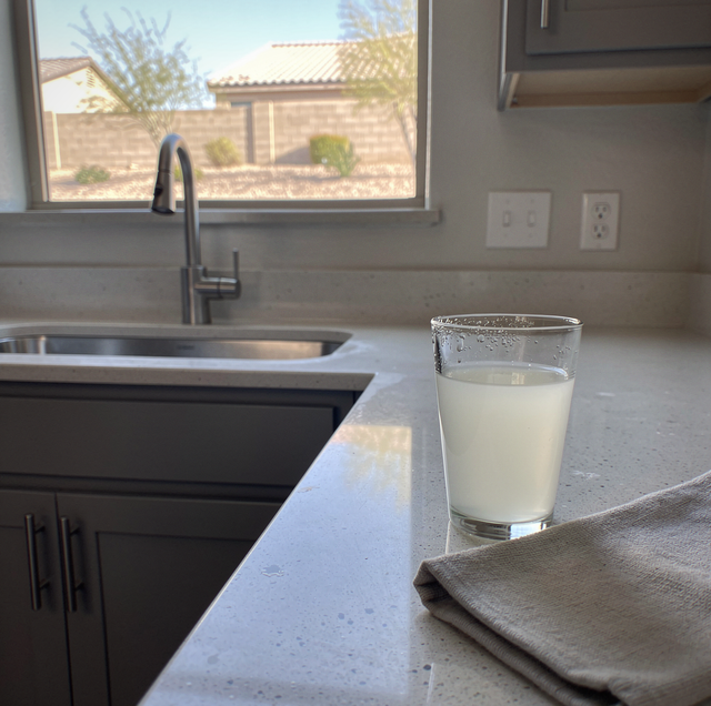 clear glass of cloudy tap water on kitchen counter