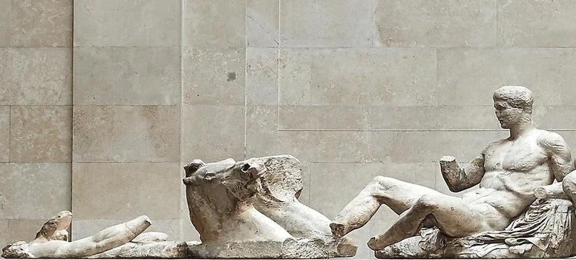 Fragmentary Parthenon pediment sculptures displayed in a museum gallery.